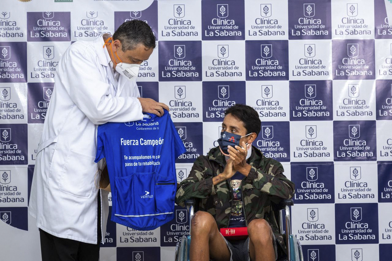 Esta imagen distribuida por la Clínica La Sabana muestra al colombiano Egan Bernal (der.), exganador del Tour de Francia, aplaudiendo junto al director de la Clínica, Juan Guillermo Ortiz (izq.), en Bogotá, el 6 de febrero de 2022.  (Foto Clínica La Sabana / AFP)