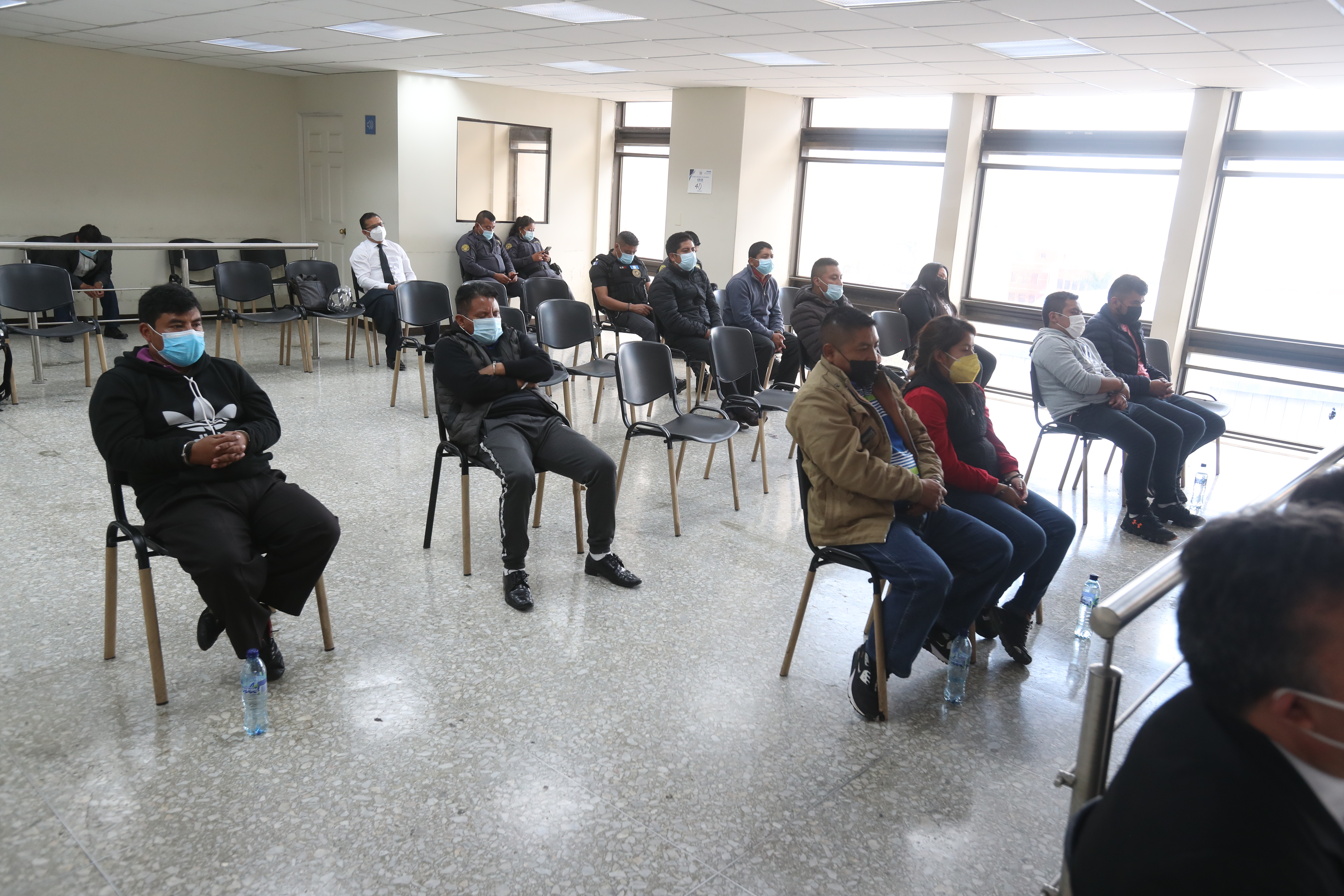 Los 10 detenidos por supuestamente integrar una red de tráfico de personas en Comitancillo, San Marcos, durante una audiencia en el Juzgado Quinto Penal. (Foto Prensa Libre: Carlos Hernández)