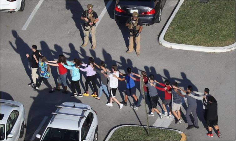 Alumnos del instituto de Parkland son escoltados por un soldado, febrero de 2018. (Foto Prensa Libre: AFP)