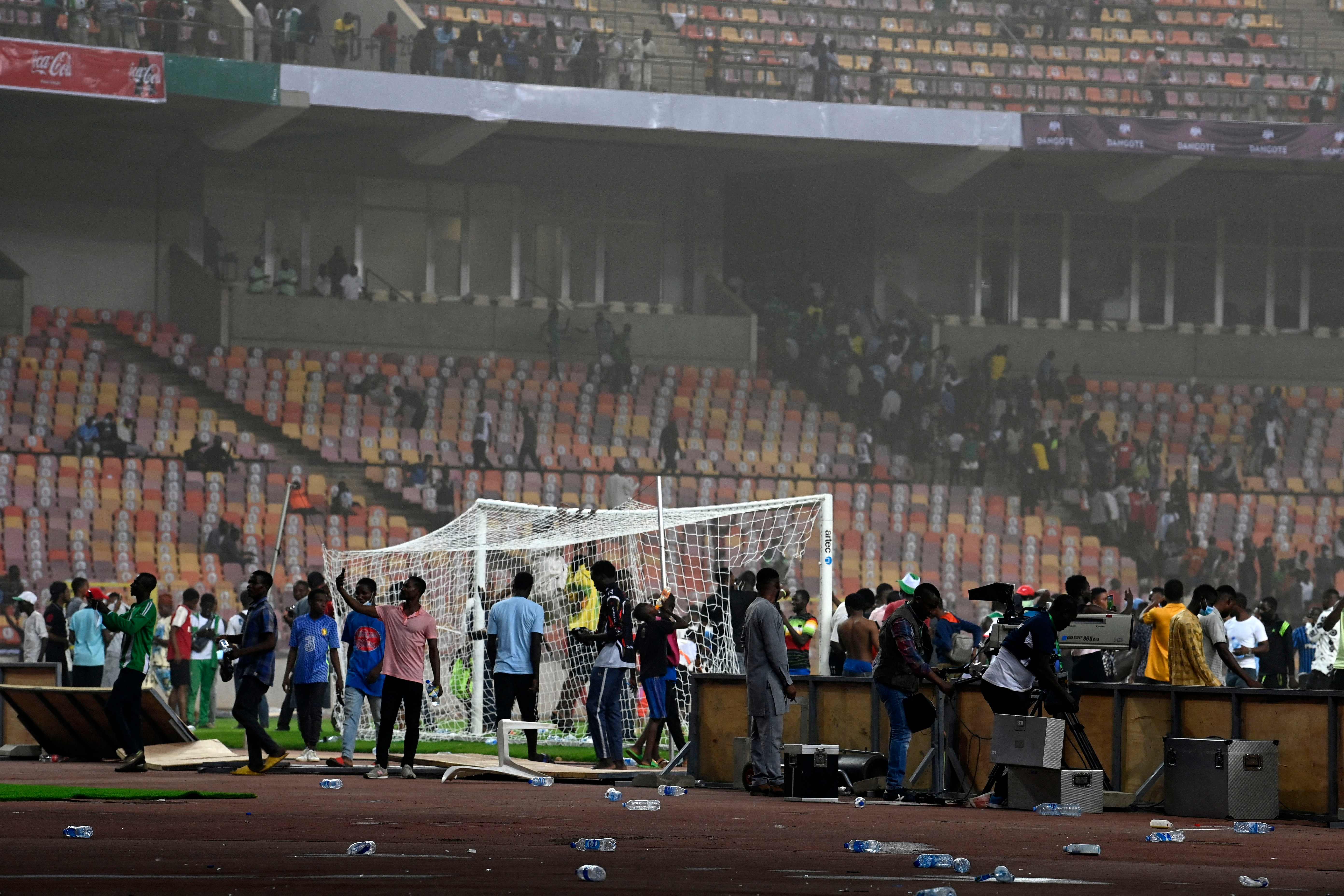 Angry football fans invade the pitch as violence broke-out following Ghana's defeat over Nigeria at the World Cup 2022 qualifying football match between Nigeria and Ghana at the National Stadium in Abuja on March 29, 2022. (Photo by PIUS UTOMI EKPEI / AFP)