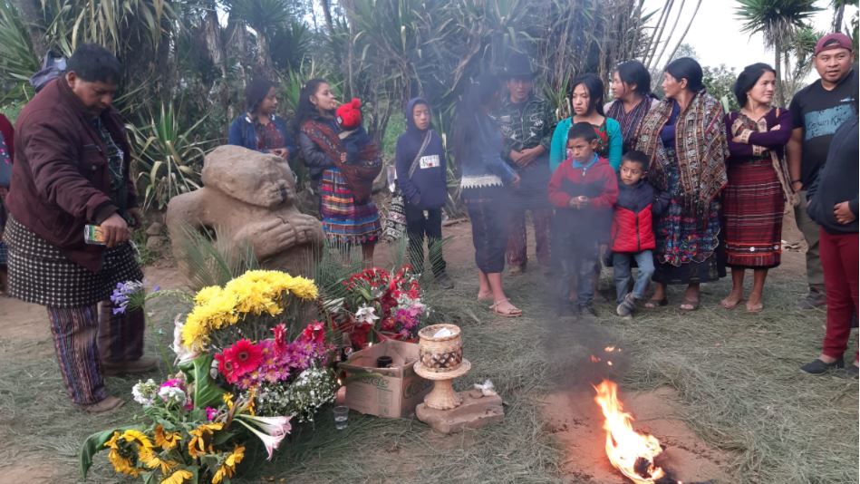 Pobladores colocan ofrendas frente al monolito descubierto en un caserío de Sololá. (Foto Prensa Libre: Fredy de León)