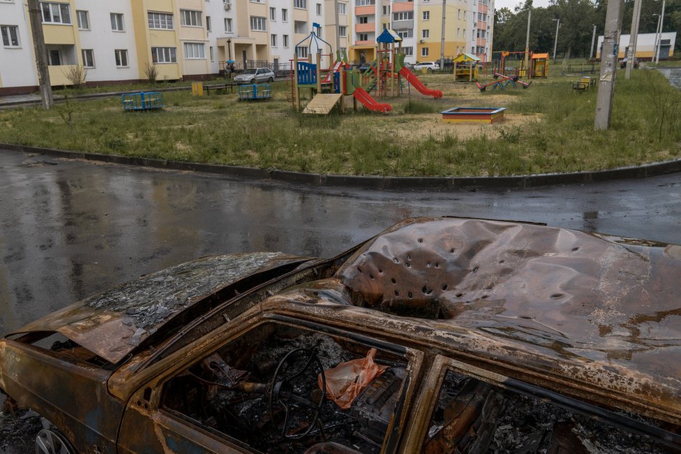 Marcas distintivas de una munición en racimo en el techo de un automóvil junto a un parque infantil en Járkiv.