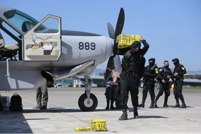 Agentes de la PNC trasladan drogas incautadas durante un operativo. (Foto Prensa Libre: Ministerio de Gobernación)