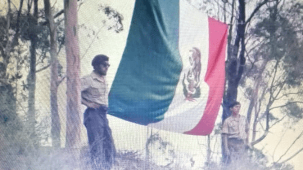 Dos boinas cafés junto a la bandera de México desplegada en Santa Catalina.
CORTESÍA DAVID SÁNCHEZ
