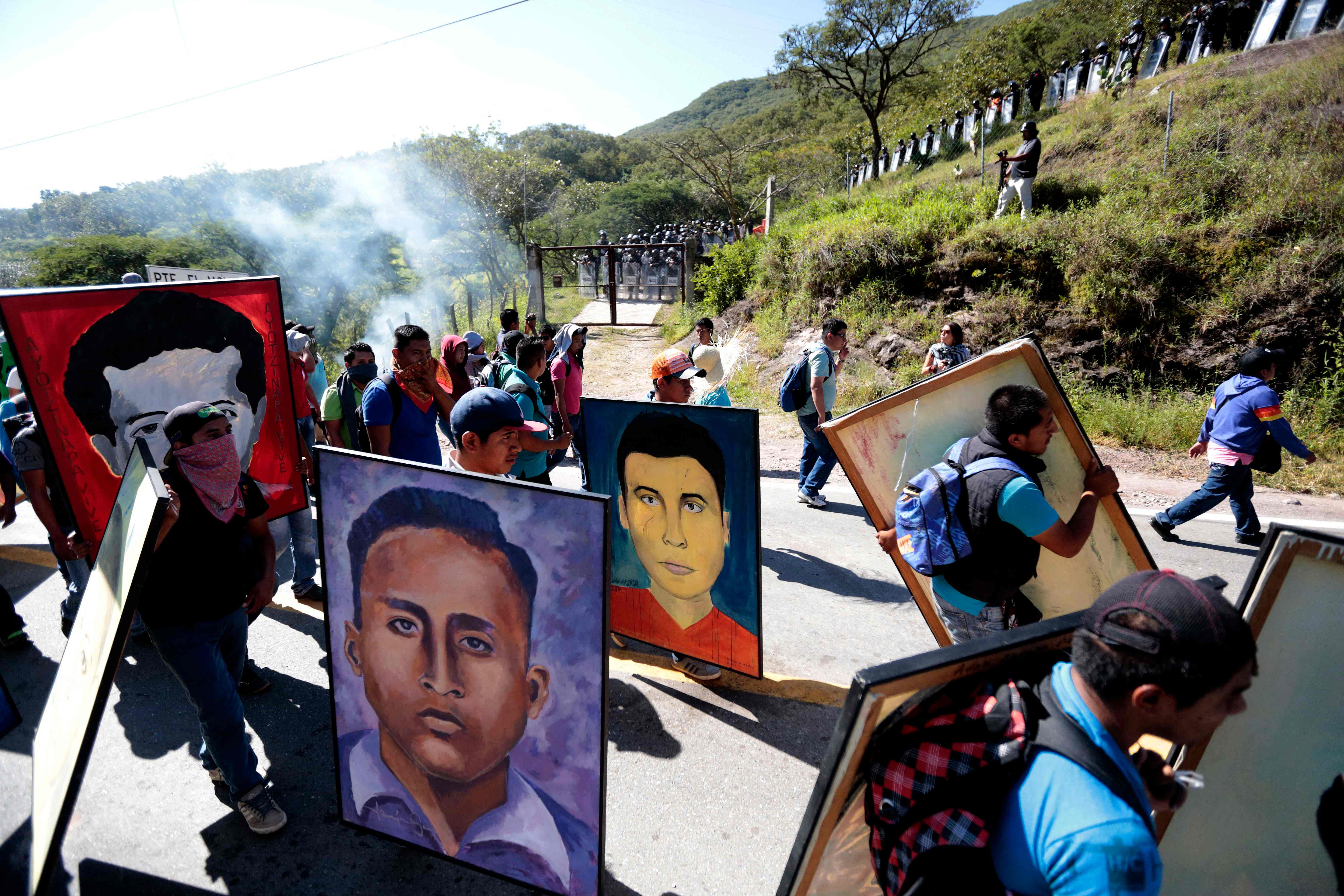 En esta foto de archivo tomada en  septiembre del 2015, estudiantes del colegio rural de  Ayotzinapa sostienen retratos de los 43 estudiantes que entonces estaban considerados como desaparecidos. (Foto Prensa Libre: AFP)