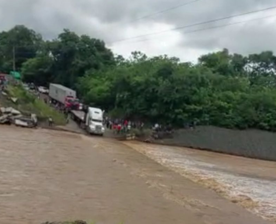 Aumento de caudal del río obstruye el paso en el kilómetro 295.5 en el puente El Túnico, El Estor, Izabal. (Foto Prensa Libre: Conred) 