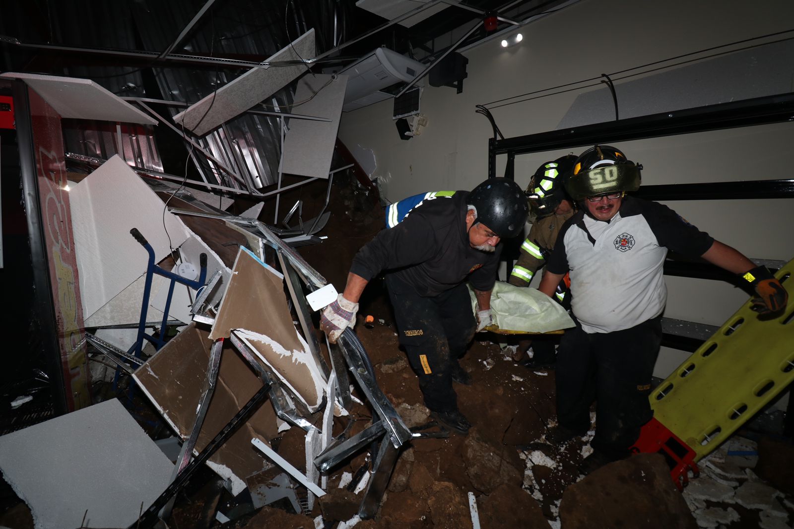 Bomberos Voluntarios extraen el cadáver de un hombre que murió soterrado en un centro comercial en la zona 6 de Mixco. (Foto Prensa Libre: CVB)