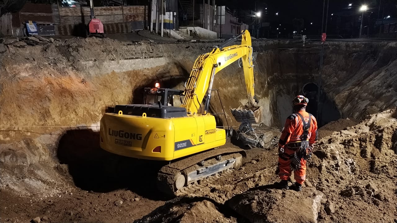 Momento en que una retroexcavadora remolca el vehículo en el que viajaban las dos mujeres que cayeron en el hundimiento de Villa Nueva. (Foto Prensa Libre: )