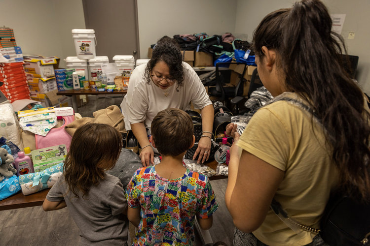Una trabajadora social de un refugio para personas sin hogar, Astrild Siolkowski, de 26 años, ayuda a una familia migrante venezolana que llegó recientemente a Nueva York. (Foto Prensa Libre: Victor J. Blue / The New York Times)