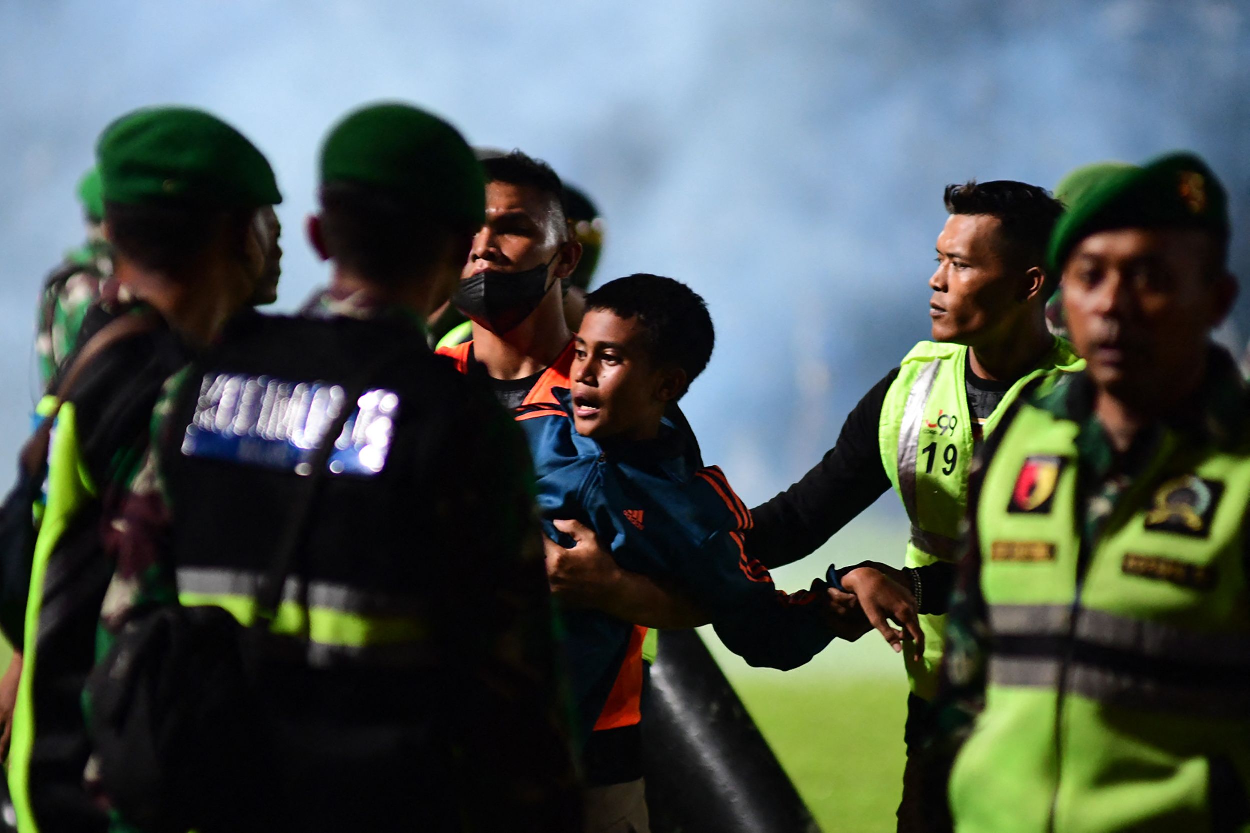 Un niño es auxiliado por las fuerzas de seguridad del estadio donde ocurrió la trágica estampida de aficionados. (Foto Prensa Libre: AFP)