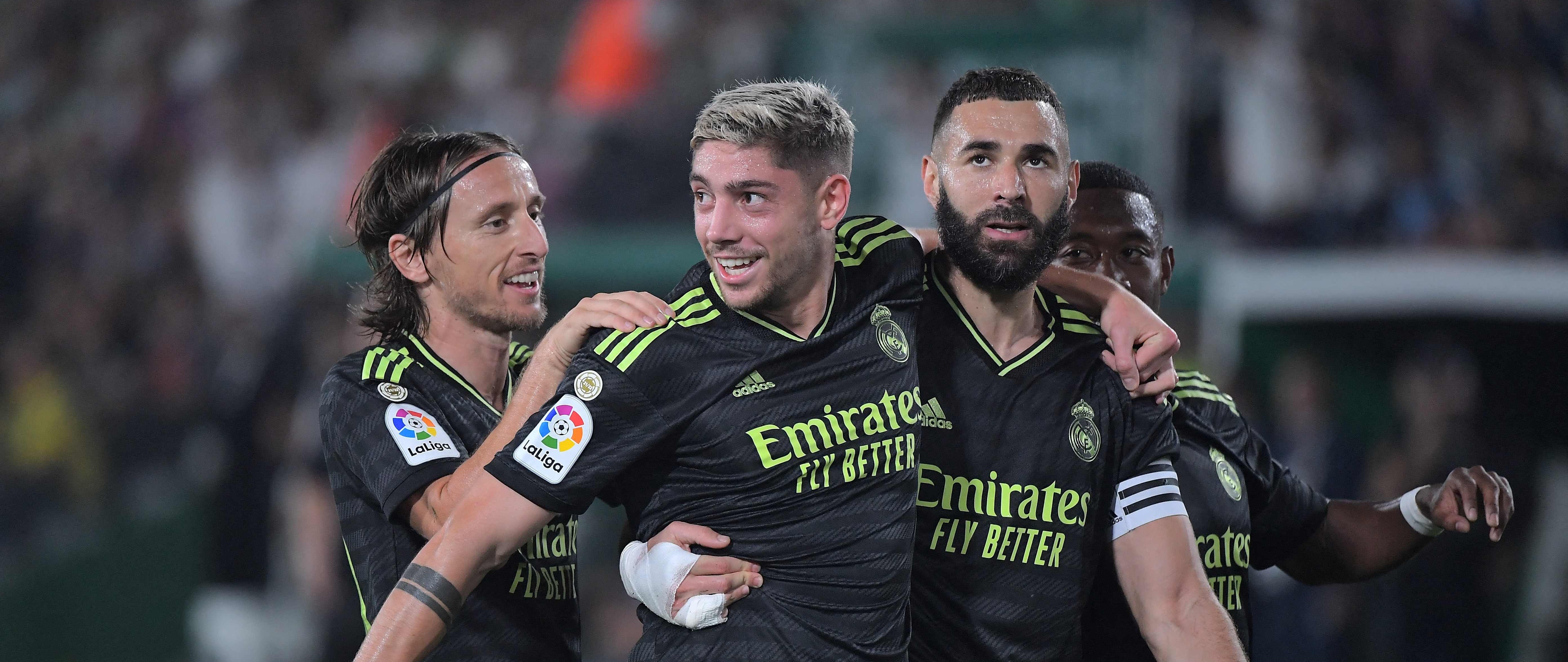 La foto que se está volviendo típica en el Madrid: Valverde y Benzema abrazados tras anotar en un partido. (Foto Prensa Libre: AFP)