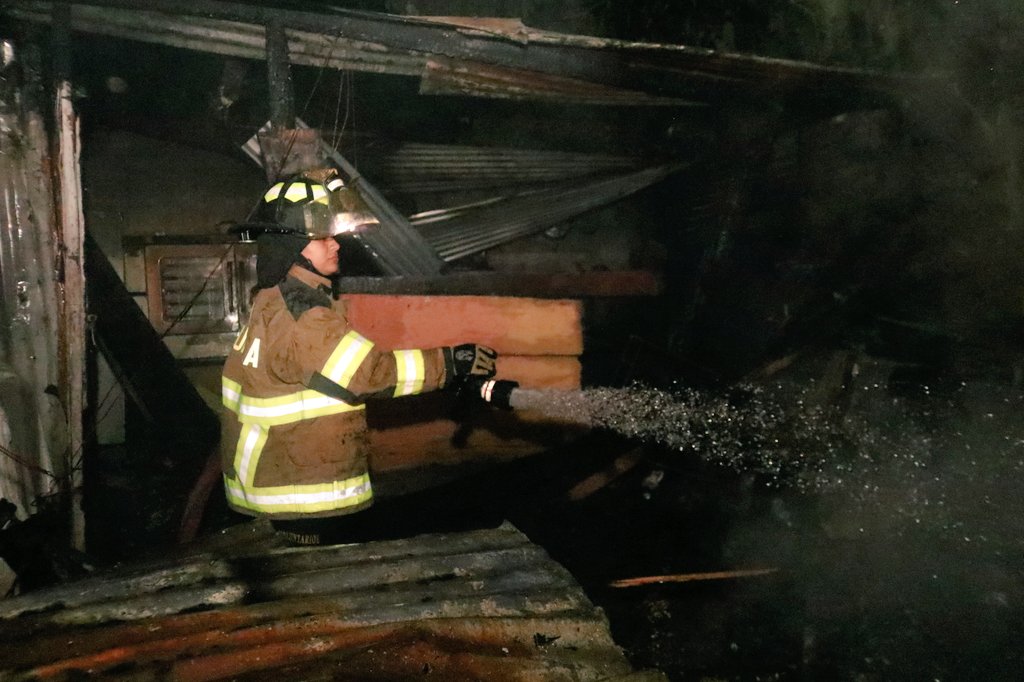 Socorristas estabilizan a una mujer afectada por un incendio en Villa Canales. (Foto Prensa Libre: Bomberos Voluntarios)