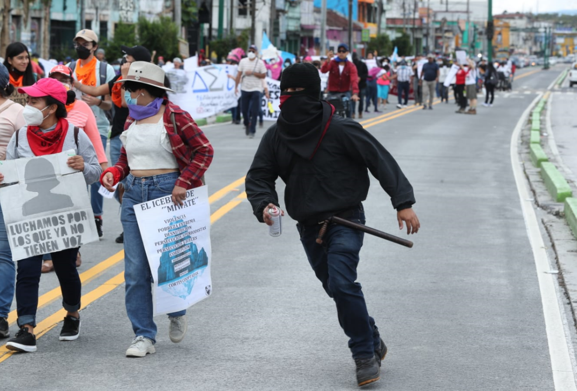 Un manifestante con el rostro cubierto se dirige a pintar una estación del Transmetro. (Foto Prensa Libre: Esbin García) 