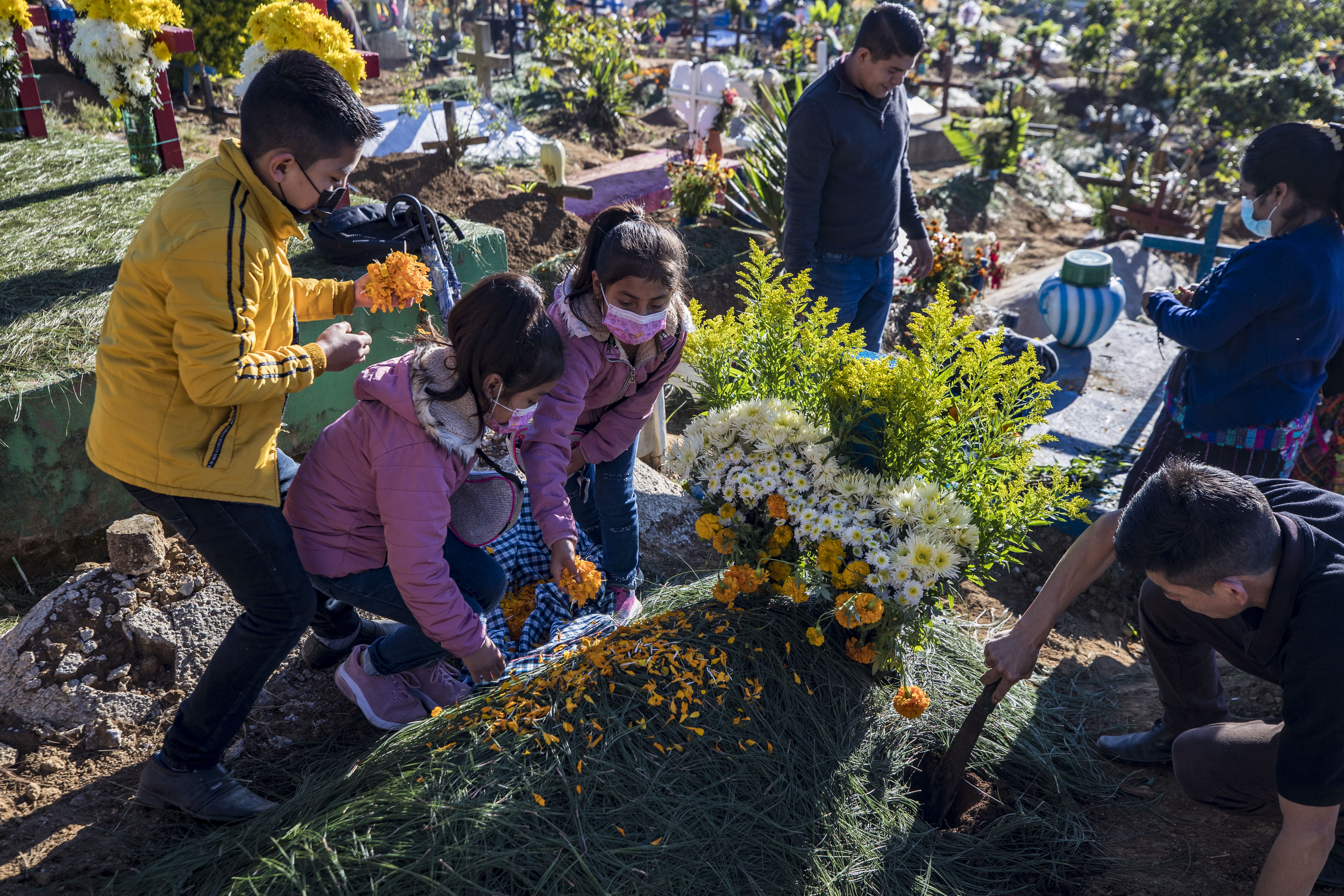 Guatemaltecos adornando tumbas durante el 1 de noviembre