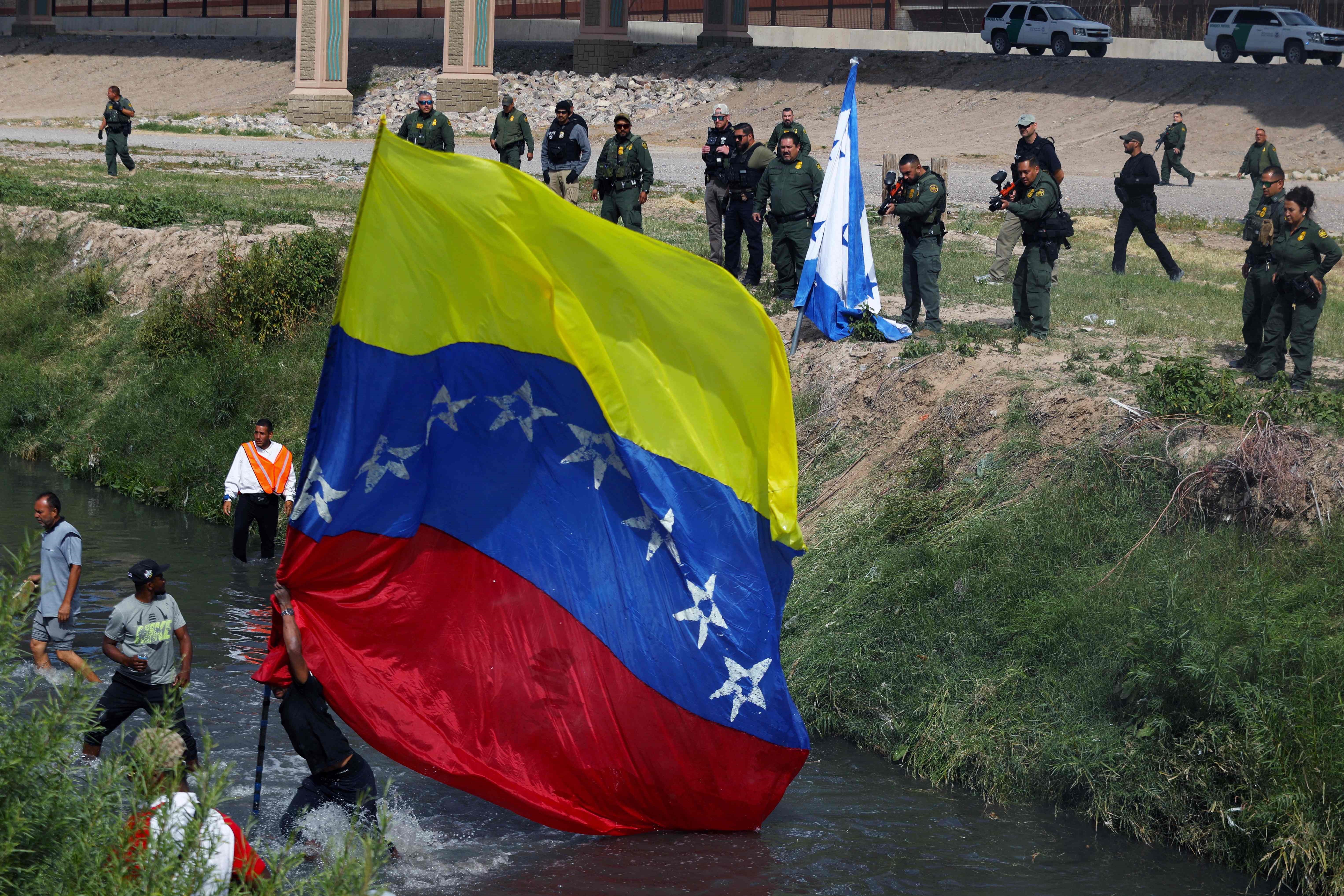 Oficiales fronterizos de EE. UU. tratan de evitar que migrantes venezolanos crucen el Río Bravo, frontera entre EE. UU. y México. (Foto Prensa Libre: AFP)