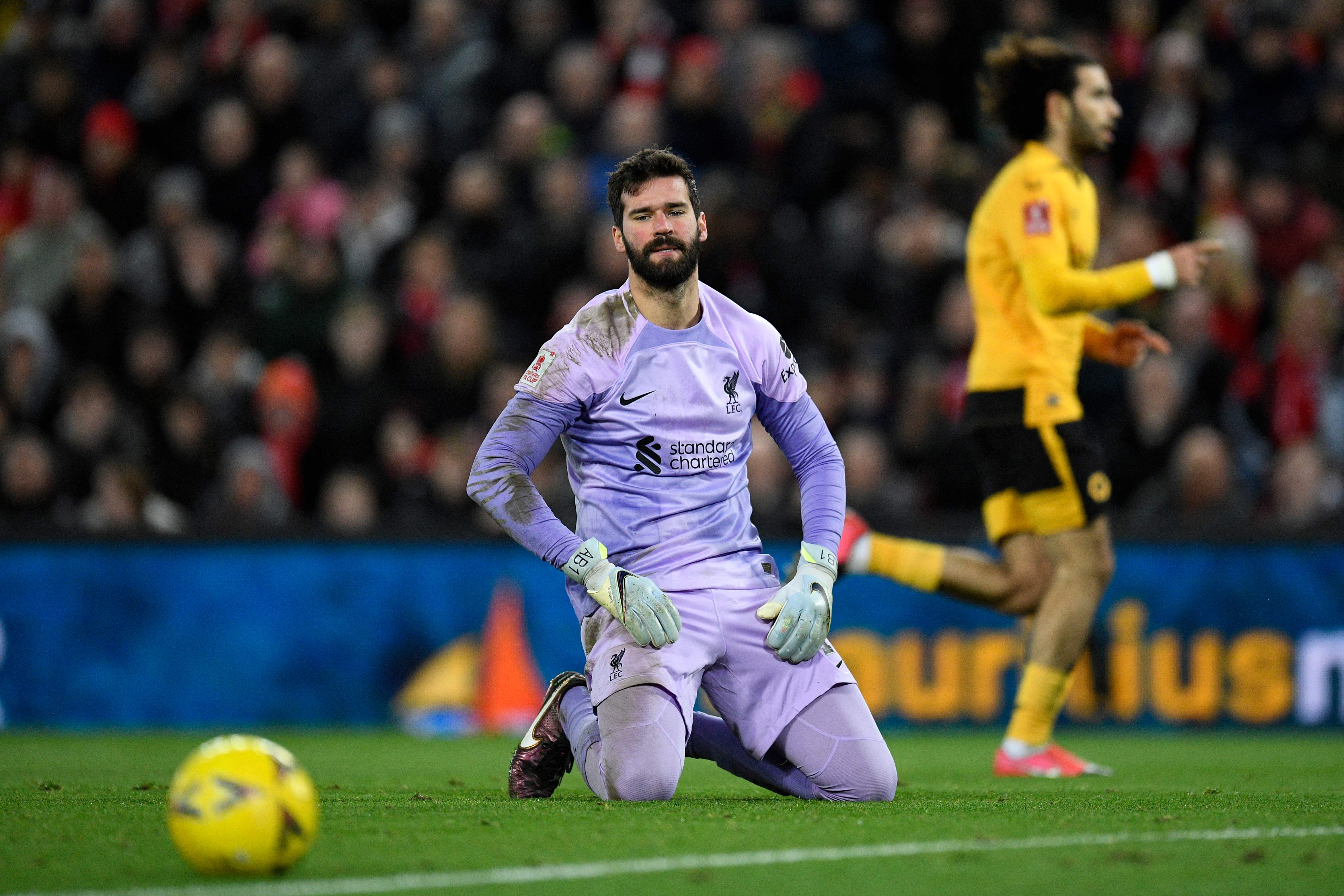 El portero brasileño del Liverpool, Alisson Becker, reacciona después de cometer un error que permitió que el delantero portugués del Wolverhampton Wanderers, Goncalo Guedes. Foto Prensa Libre (AFP)