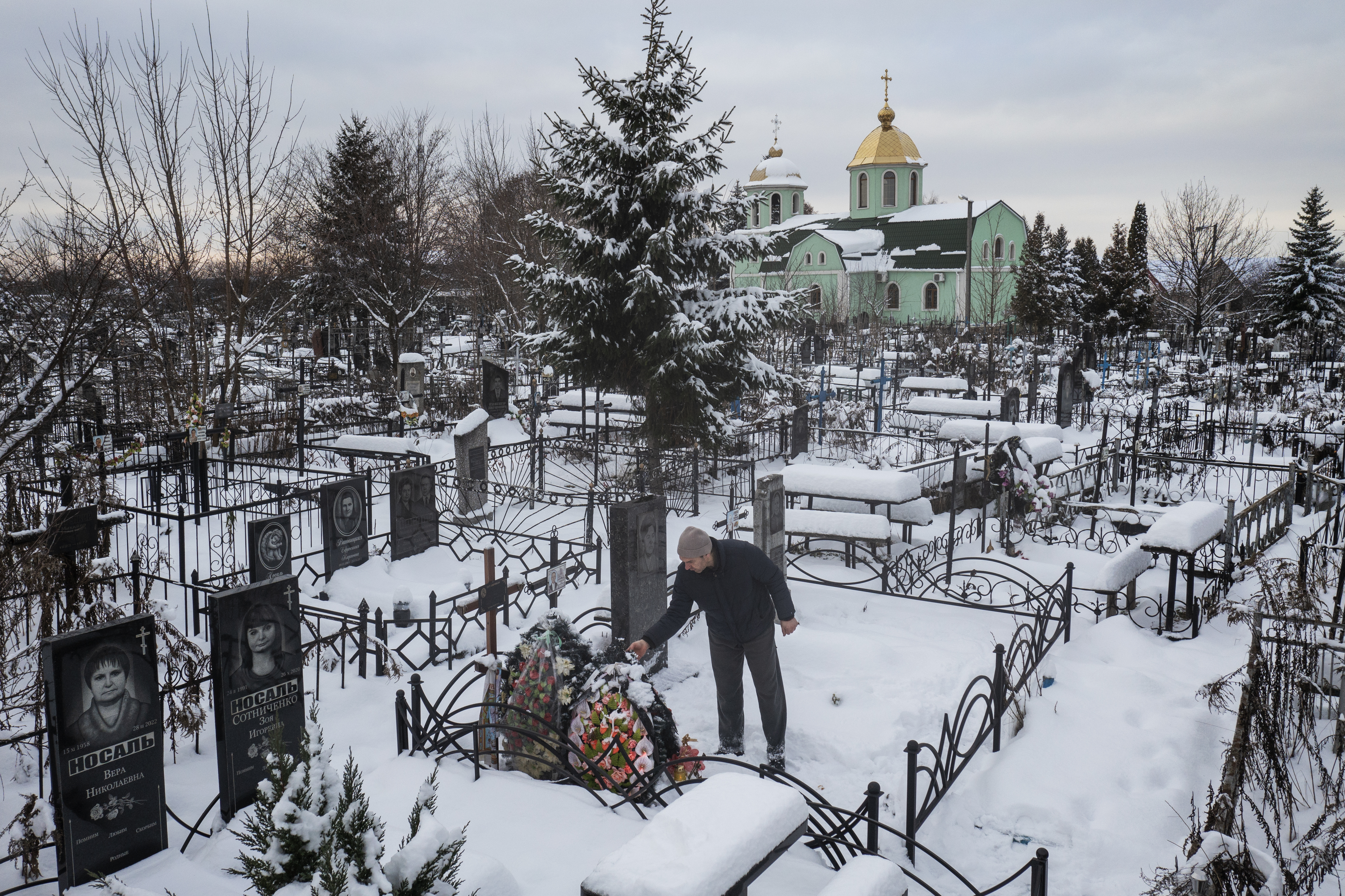 Yuriy Kryvenko visitando la tumba de su padre, Oleksandr Kryvenko, asesinado por un soldado ruso en marzo en Bucha, Ucrania, el 4 de diciembre de 2022. (Foto Prensa Libre: David Guttenfelder/The New York Times)