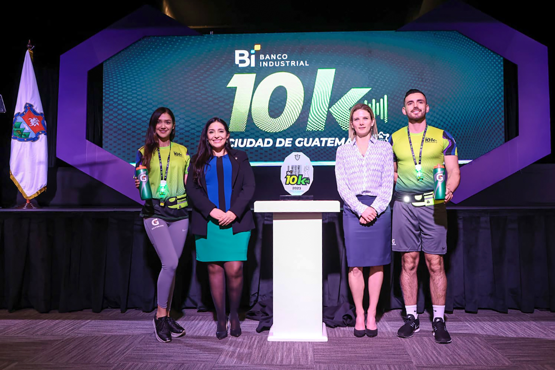 Diana Estrada, subdirectora de Convivencia Social de la Municipalidad de Guatemala; y María José Paiz, de Relaciones Institucionales de Banco Industrial (Centro); junto a los modelos que lucen las playeras y medallas de la carrera. Foto Prensa Libre: Cortesía