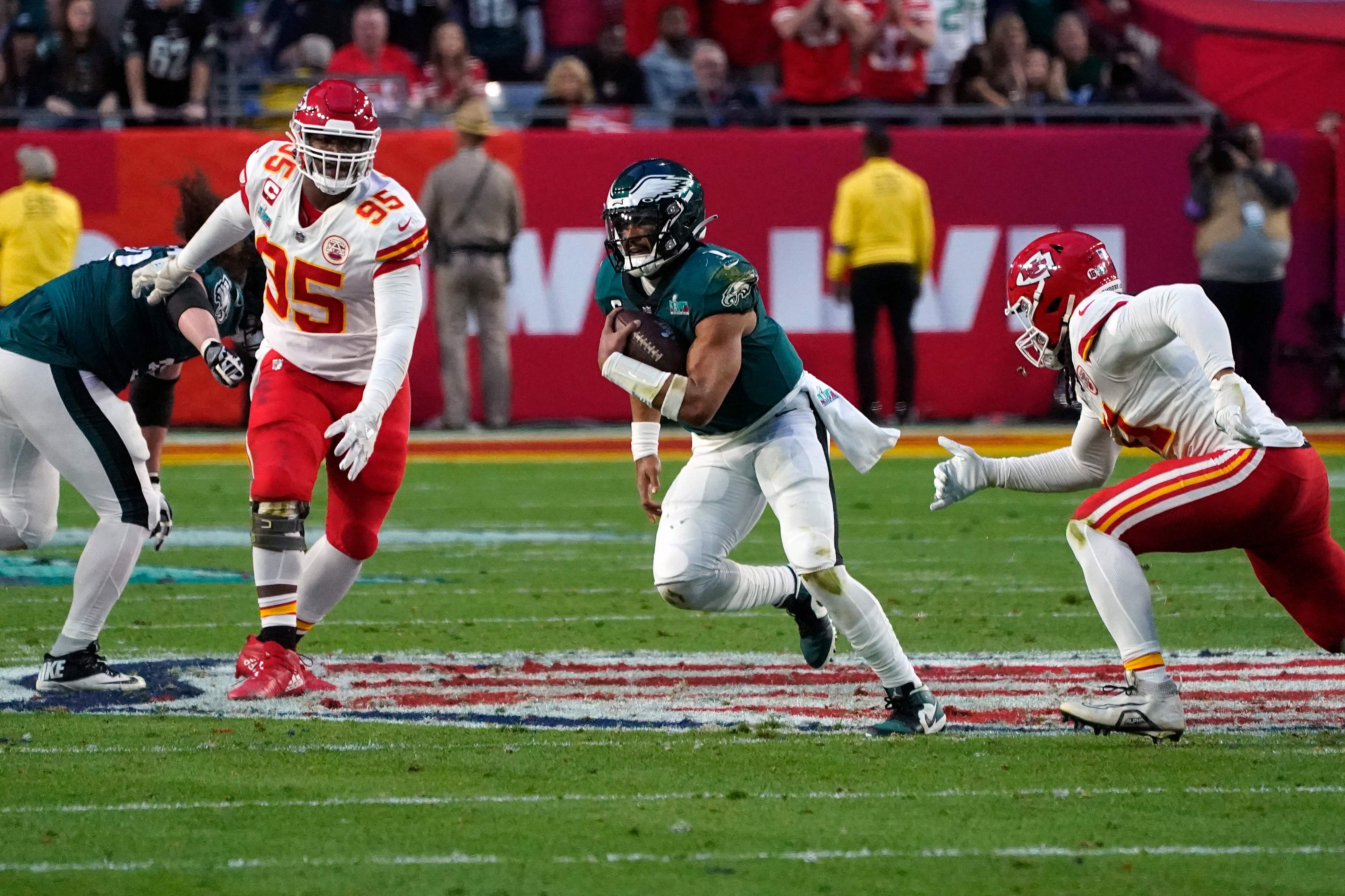 El mariscal de campo de los Philadelphia Eagles, Jalen Hurts, atraviesa a los jugadores de los Kansas City Chiefs durante el Super Bowl LVII entre los Kansas City Chiefs y los Philadelphia Eagles en el State Farm Stadium en Glendale, Arizona. Foto Prensa Libre (AFP)