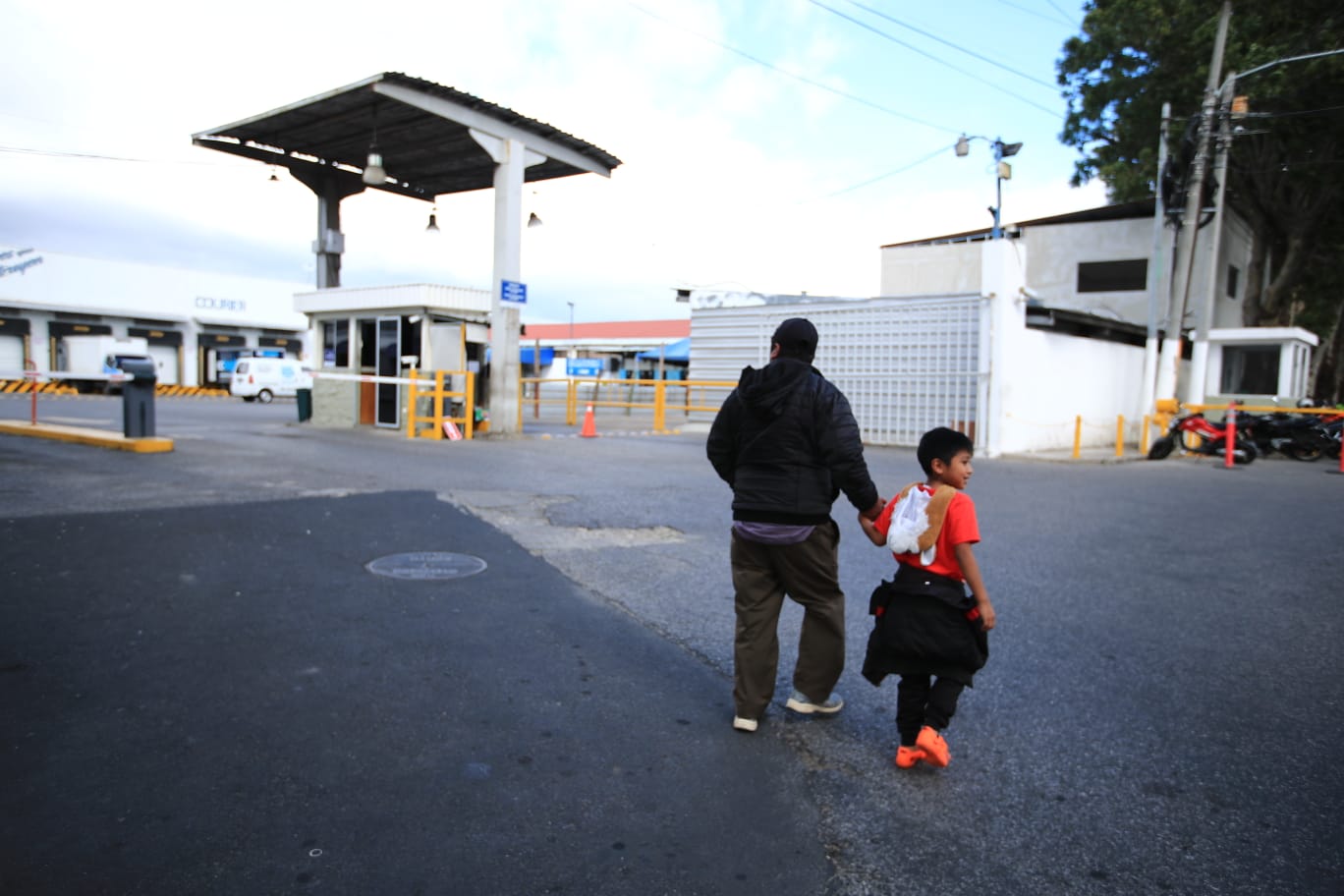 Andrés Alvarado junto a su nieto esperan en la zona 13 la llegada de los cuerpos de sus amigos y vecinos, migrantes que fallecieron en México. (Foto Prensa Libre: Carlos Hernández Ovalle) 