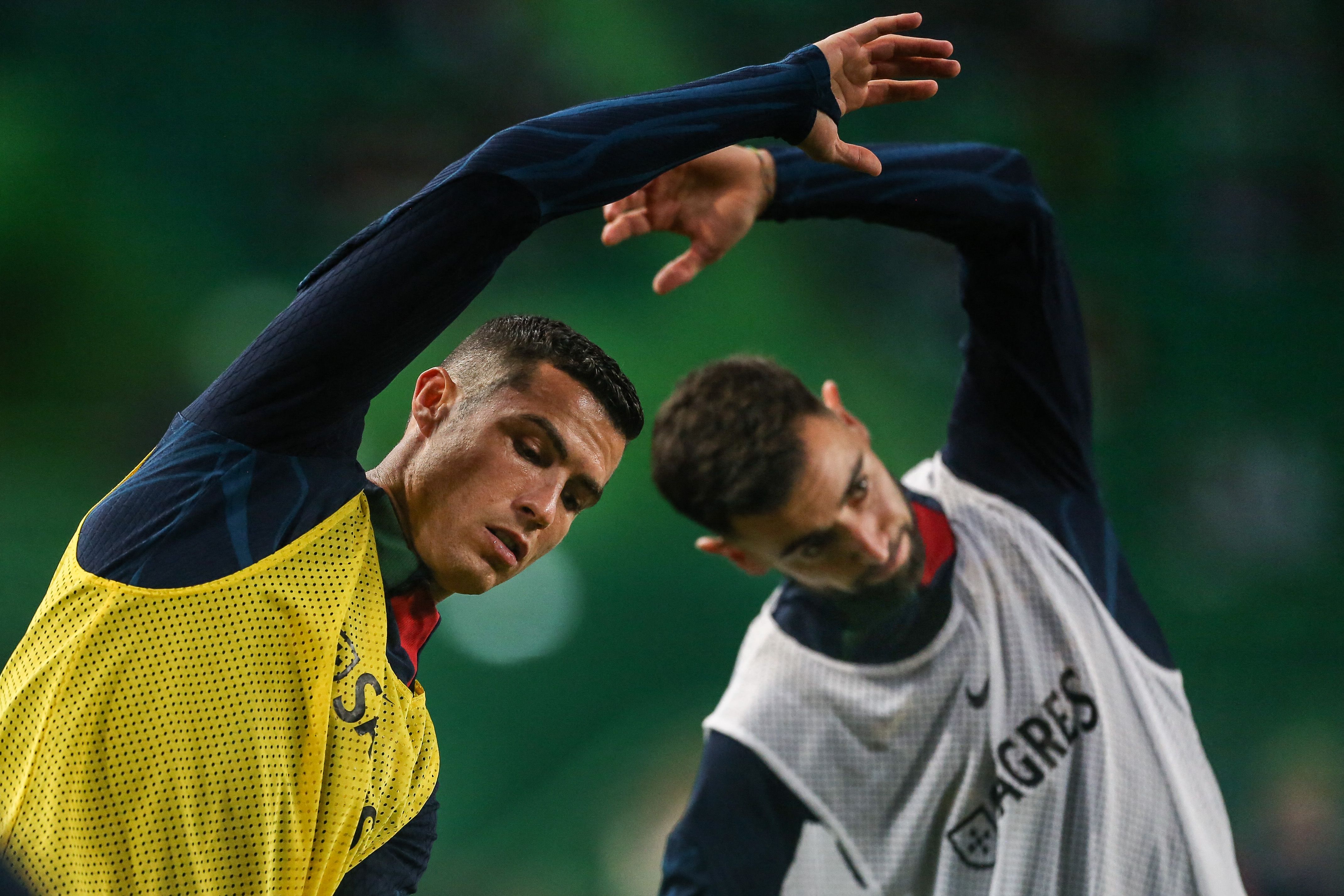 El delantero de Portugal Cristiano Ronaldo (l) y el centrocampista de Portugal Bruno Fernandes se calientan antes del partido de clasificación de la UEFA para la Eurocopa 2024 entre Portugal y Liechtenstein en el estadio José Alvalade de Lisboa el 23 de marzo de 2023. Foto Prensa Libre (AFP)