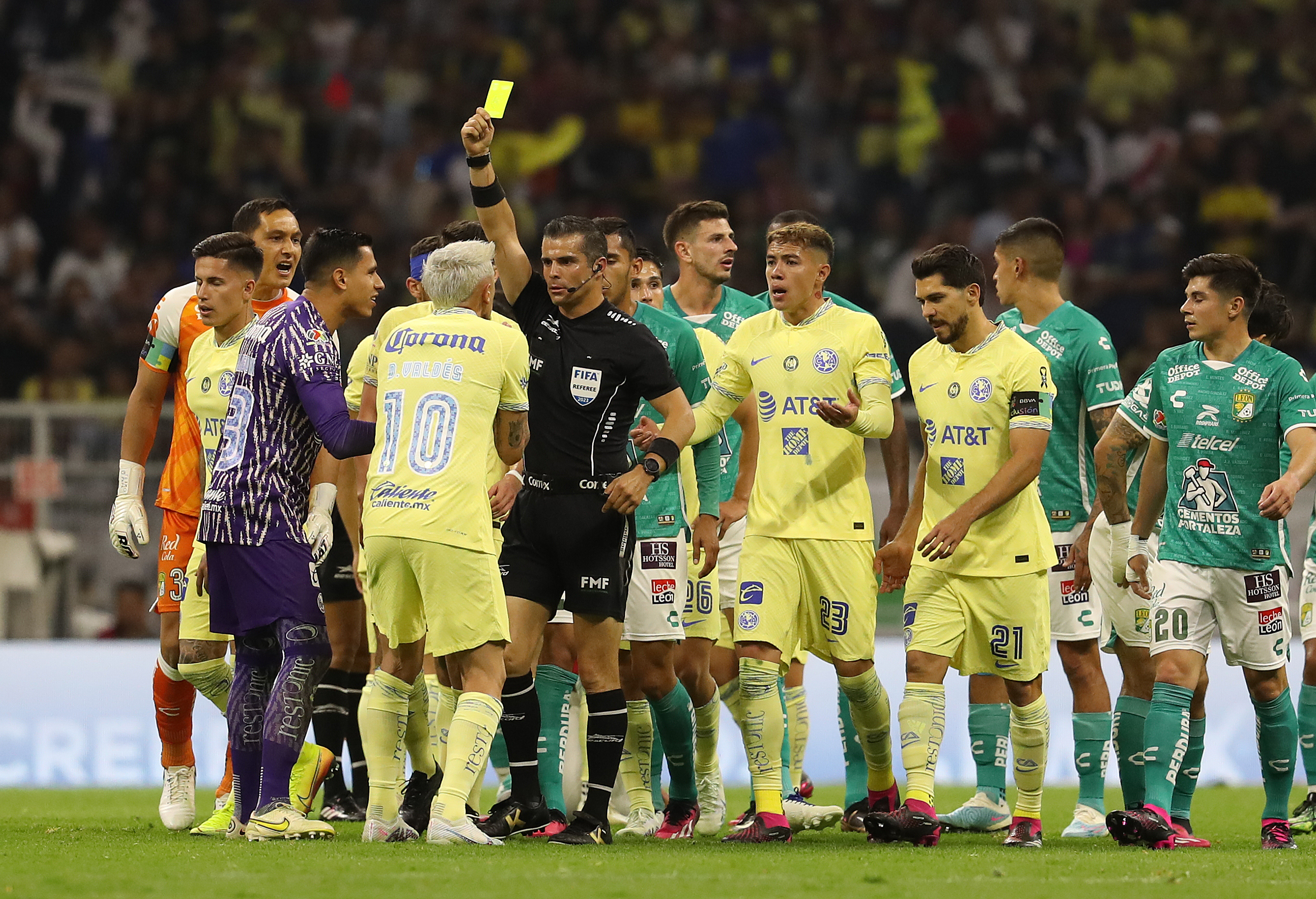 El arbitro central Fernando Hernández (c) muestra tarjeta amarilla de amonestación a Diego Valdés (i), durante un juego de la jornada 13 del torneo Clausura 2023 del fútbol mexicano hoy, en el estadio Azteca de Ciudad de México  Foto Prensa Libre (EFE)