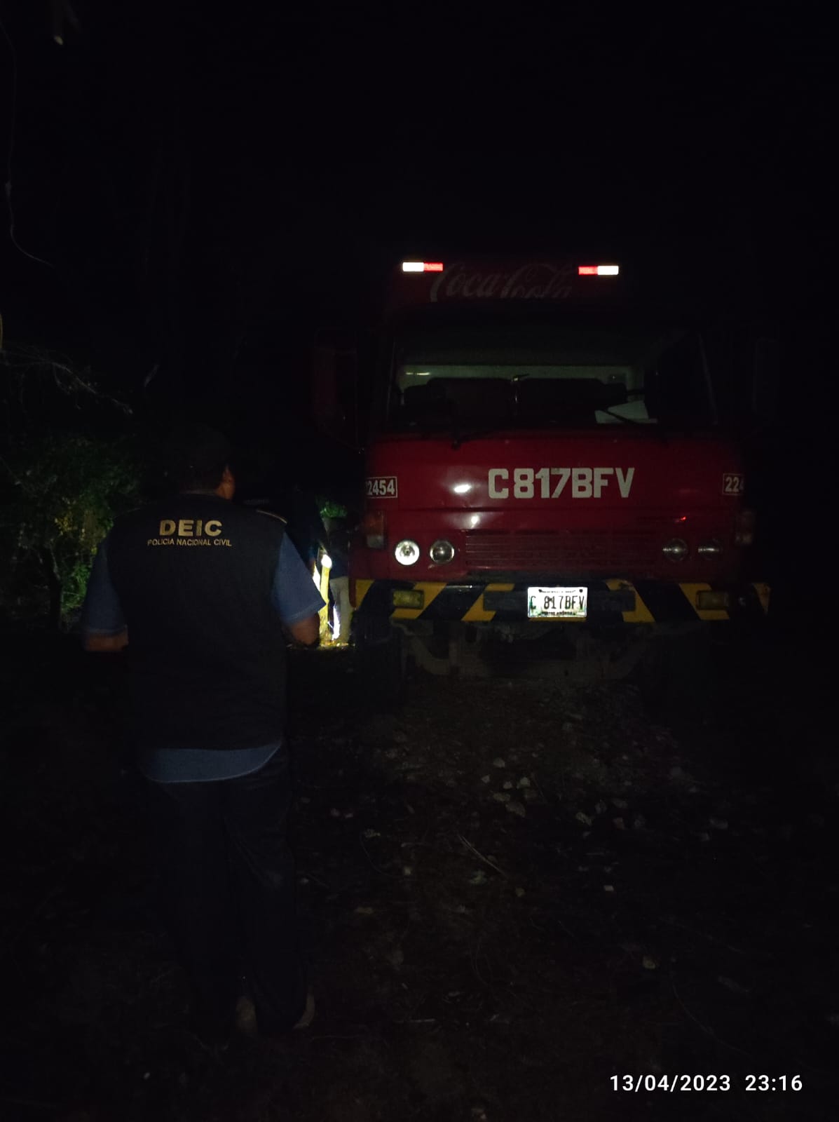 Investigadores de la Policía Nacional Civil procesa la escena donde delincuentes abandonaron un camión de una embotelladora después de haberlo asaltado. (Foto Prensa Libre: cortesía PNC).