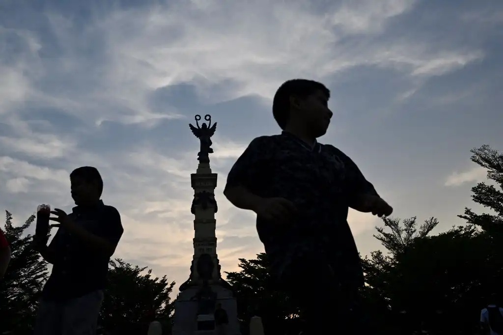 Los niños se divierten en la Plaza Libertad, donde la gente se reúne en las noches para bailar y tocar música en el centro histórico de San Salvador. (Foto Prensa Libre: AFP)