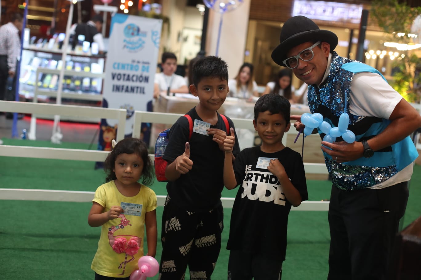 Niños votando reciben globos'