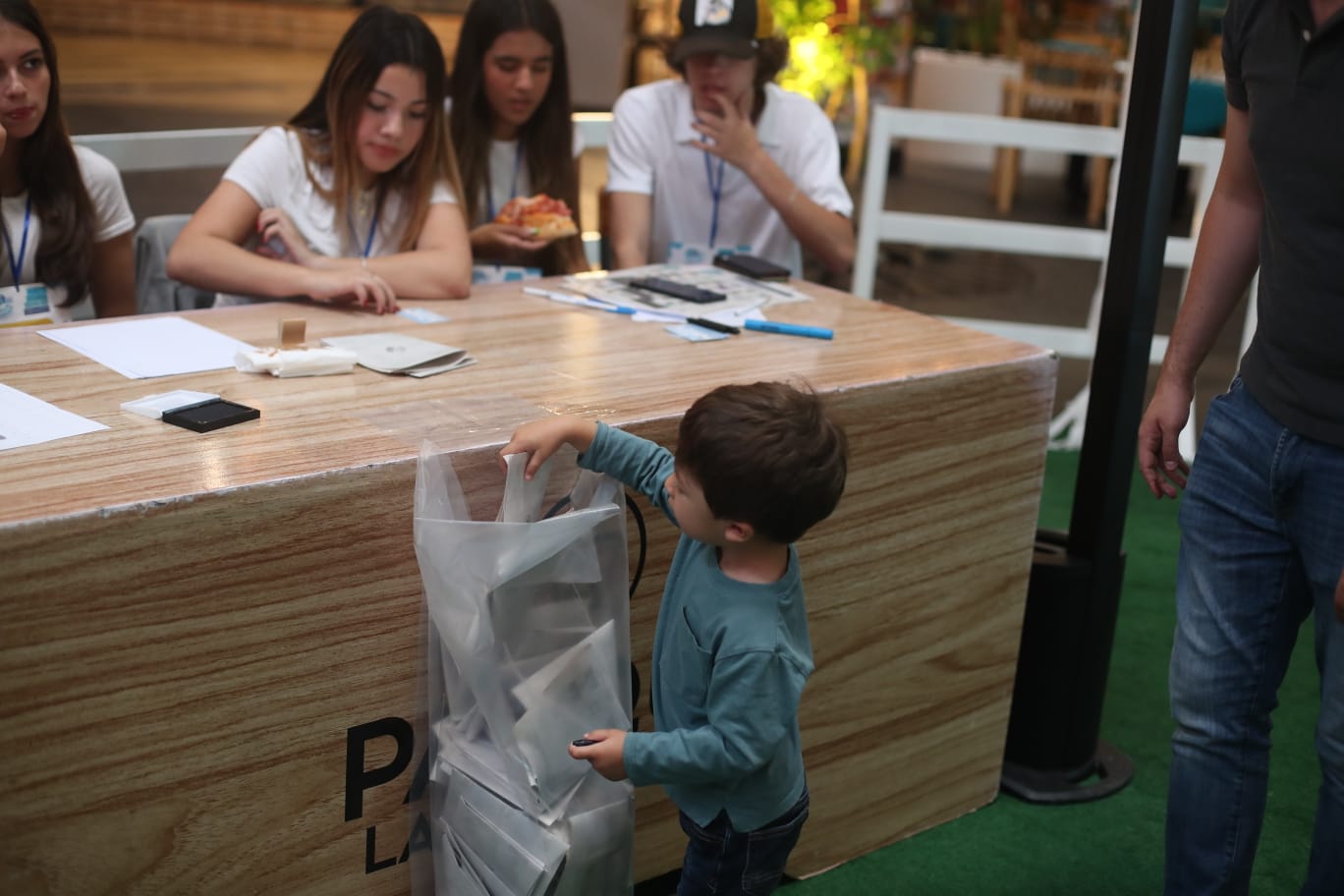 Niño deposita su voto en la urna'