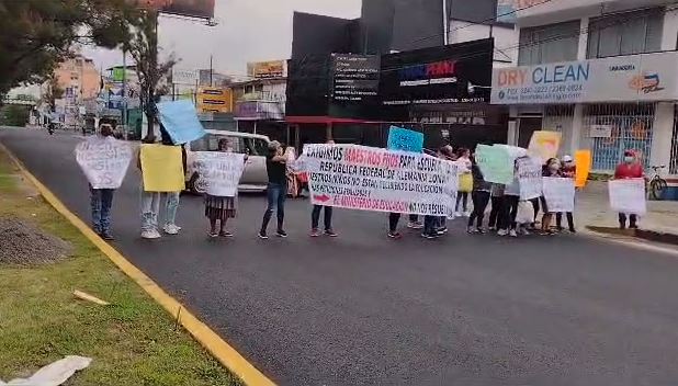 Padres de familia de la Escuela Oficial Urbana Mixta 100 República Federal de Alemania, de la Colonia Tecún Umán, zona 15 de la capital, bloquearon el paso de vehículos sobre el bulevar Vista Hermosa para exigirle al Ministerio de Educación (Mineduc) que contrate cinco maestros. (Foto Prensa Libre: captura de video)