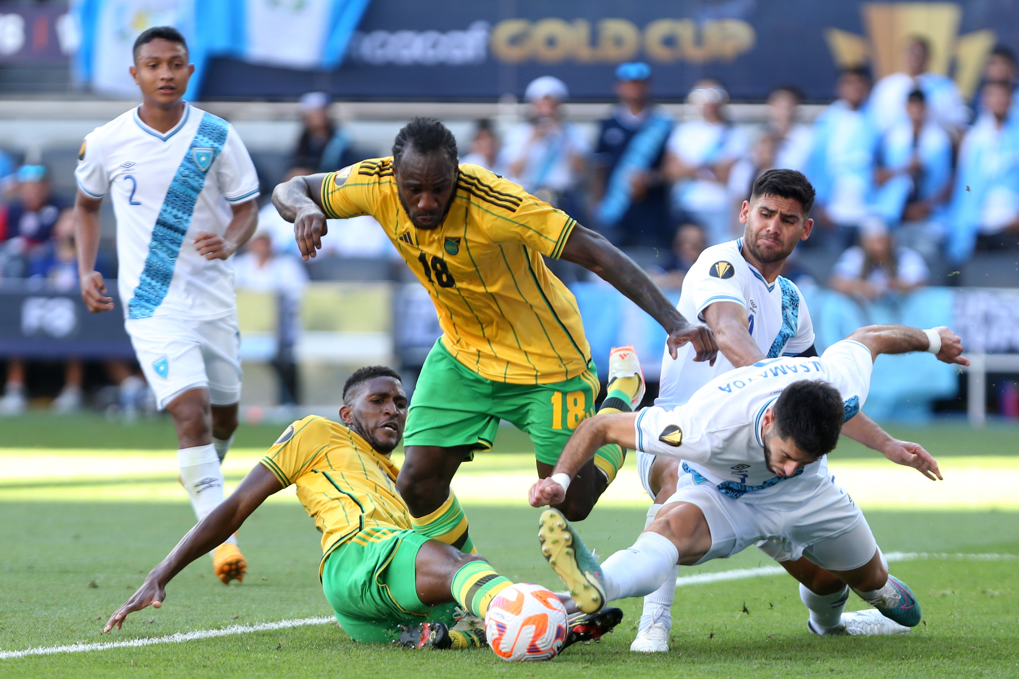 Damion Lowe (i) y Michail Antonio (c) de Jamaica en acción contra Nicolas Samayoa de Guatemala