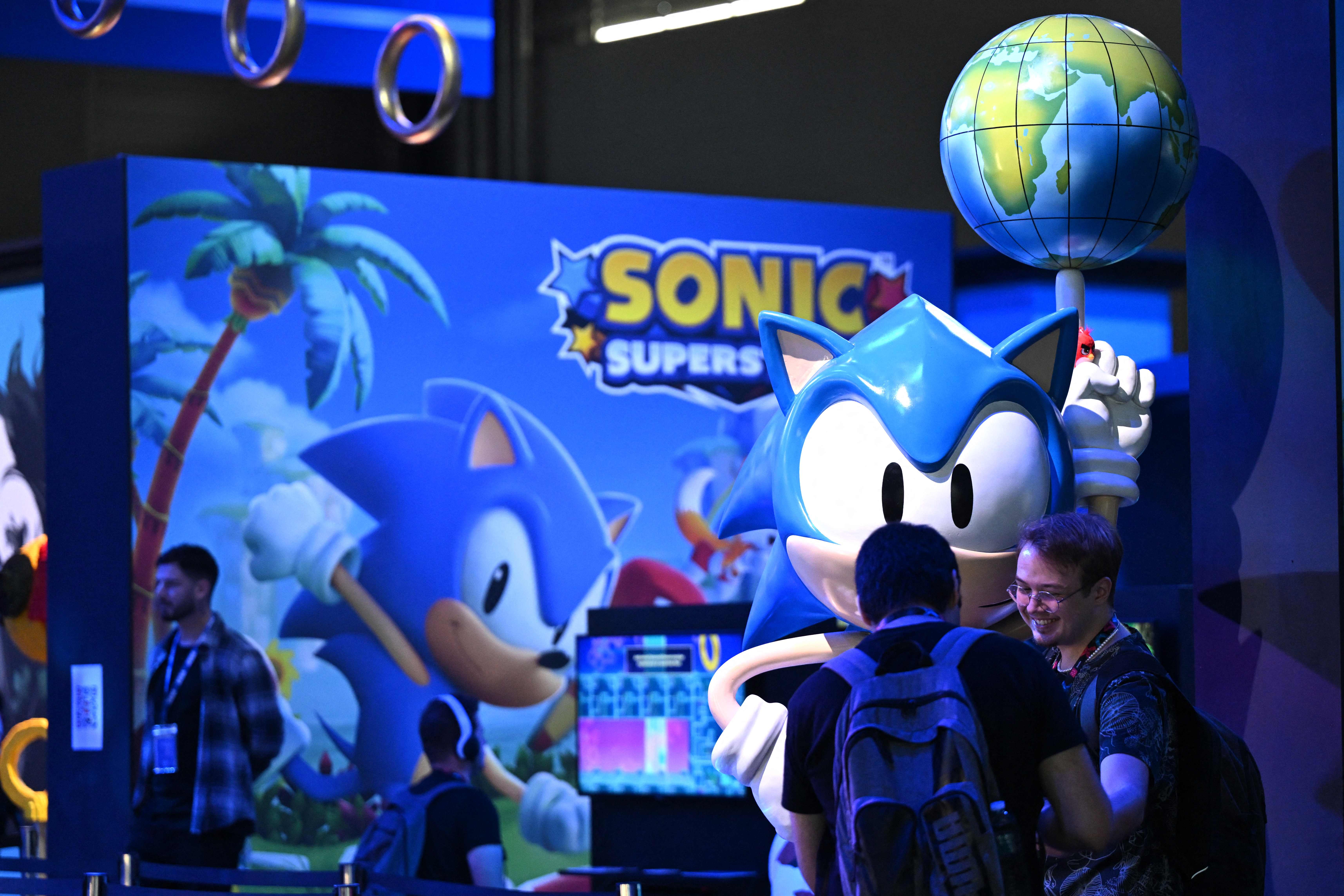 Visitors play the Sonic Superstars game at the Sega booth at the Gamescom video game fair in Cologne, western Germany on August 23, 2023. According to the organisers, around 1,100 exhibitors from 53 countries will be presenting their products during the fair running until August 27, 2023. (Photo by Ina FASSBENDER / AFP)