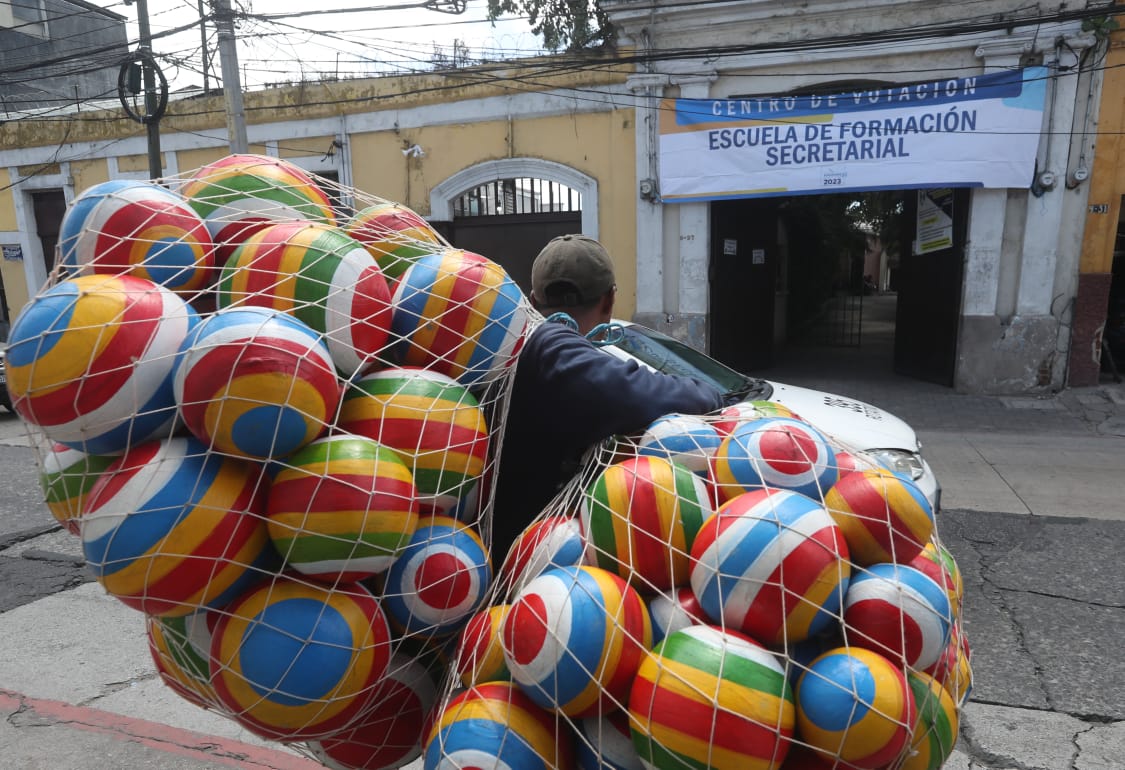 Un vendedor ambulante pasa frente al centro de votación ubicado en la Escuela de Formación Secretarial en la zona 1 capitalina.'