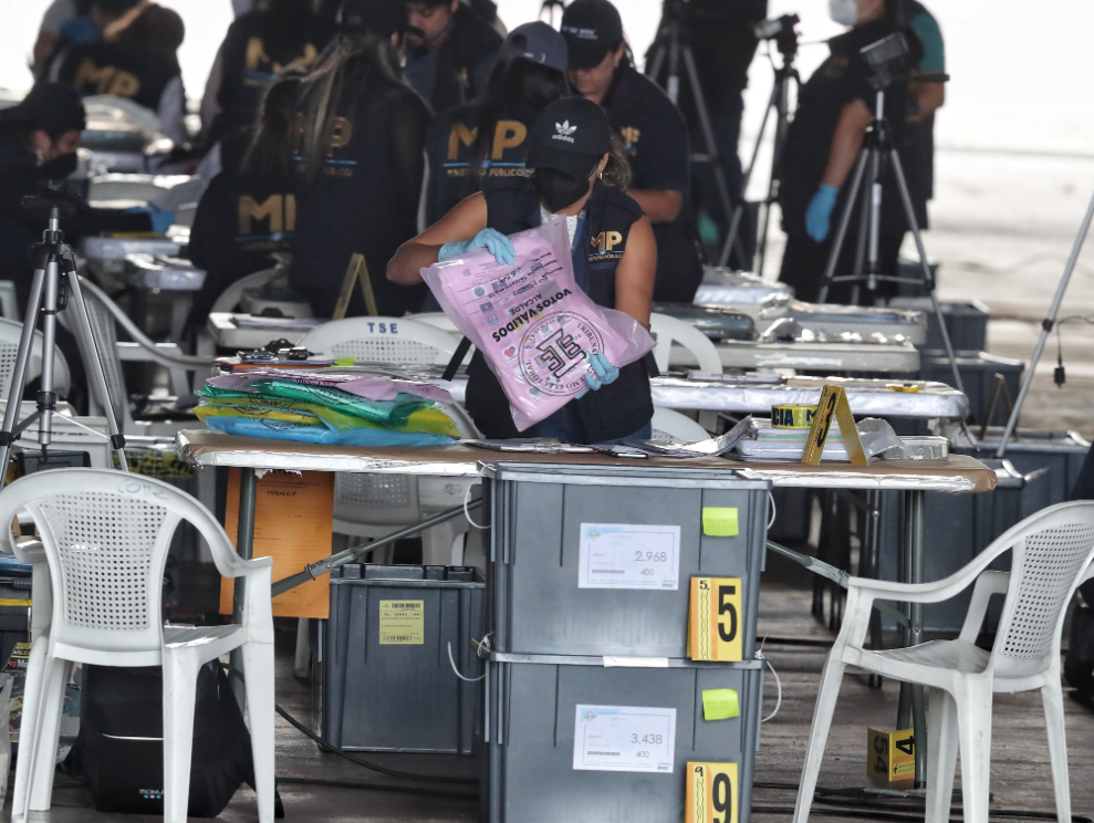 Un miembro del Ministerio Público revisa las papeletas de elección municipal de una de las cajas electorales abiertas.'