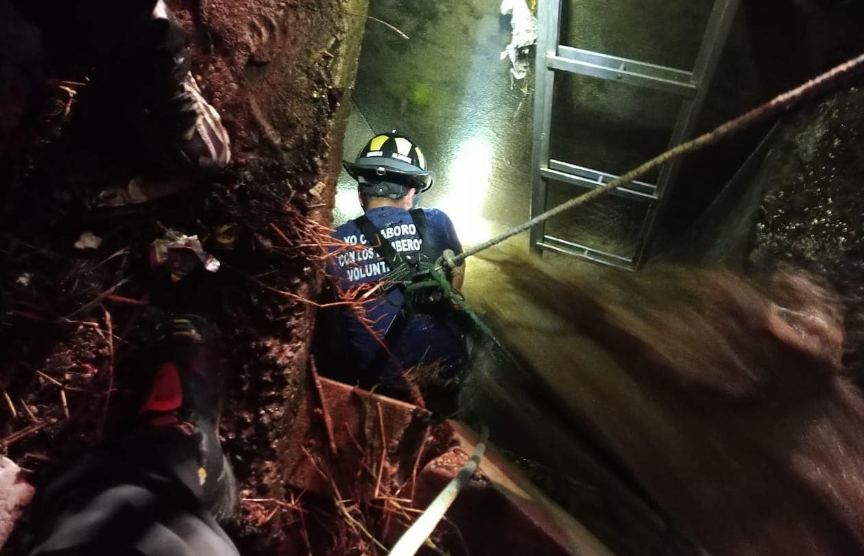 Este es el momento en que el caballero bombero, Manolo Olivares, desciende al tragante para rescatar a Antonio de Paz Gómez, de 73 años, que cayó accidentalmente en el lugar con su bicicleta. (Foto Prensa Libre: Bomberos Voluntarios 54 Compañía).