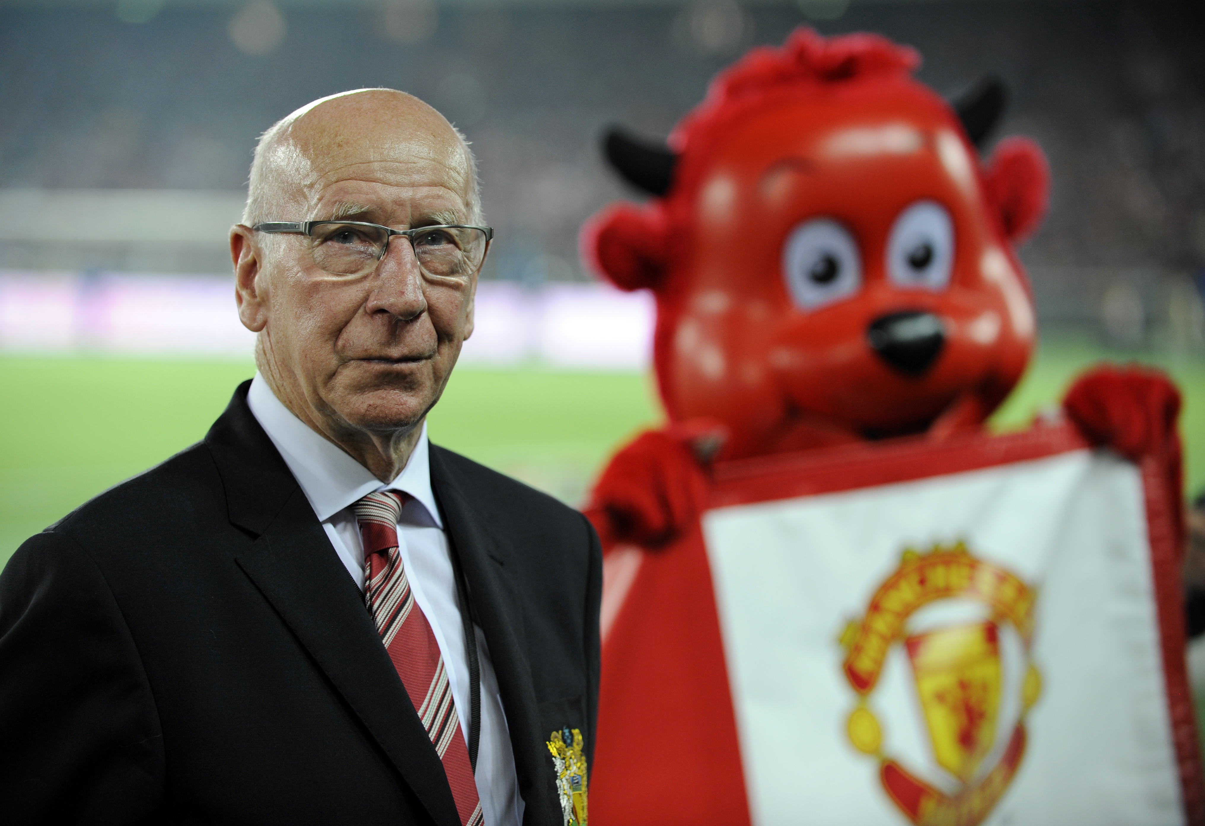 La leyenda del Manchester United, Sir Bobby Charlton, posa junto a la mascota del club durante un amistoso ante el Yokohama F. Marinos cerca de Tokyo, Japón, el 23 de julio del 2013. (Foto Prensa Libre: EFE)