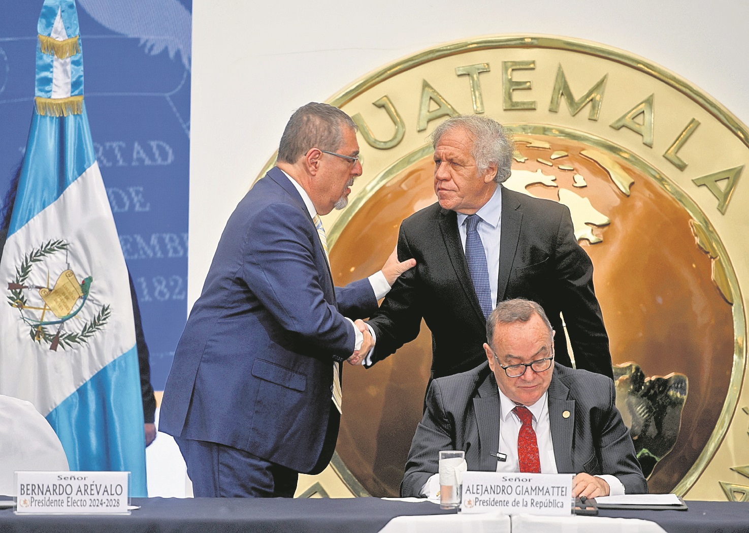 Luis Almagro, secretario de la OEA, saluda al presidente electo Bernardo Arévalo, el día en que participó en la primera reunión de transición por invitación de Alejandro Giammattei (sentado)