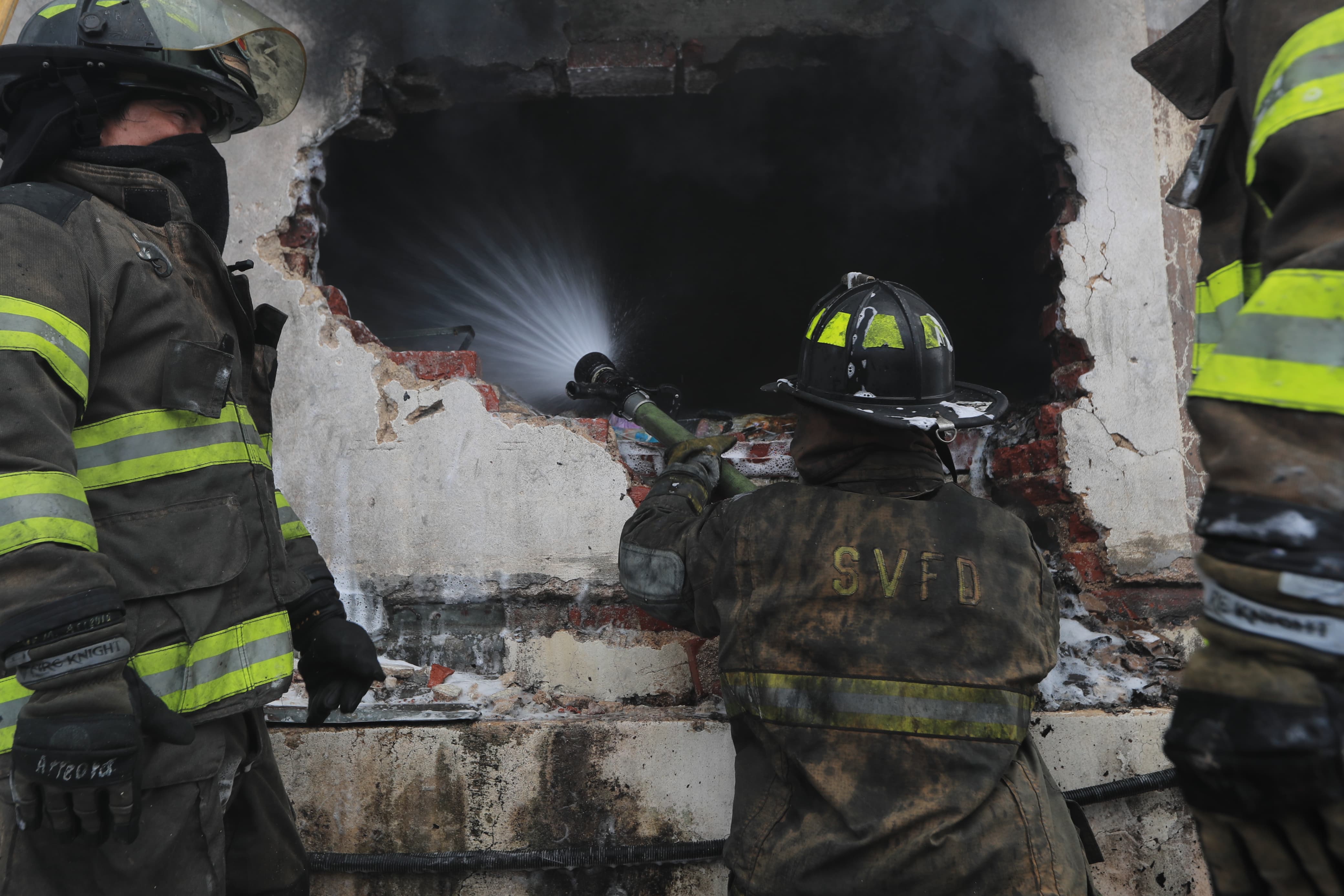 Bomberos apagan incendio con mangueras'