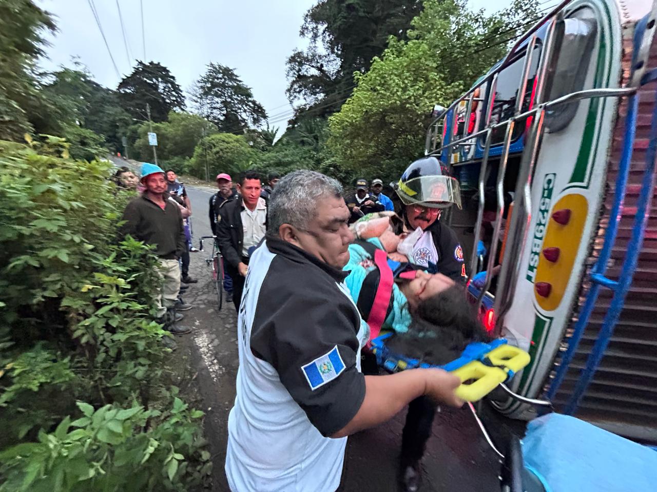 Socorristas trasladan a uno de los heridos del accidente en km 24 de la ruta a residenciales San José, en San José Pinula, en donde un bus volcó. (Foto Prensa Libre: Bomberos Voluntarios)