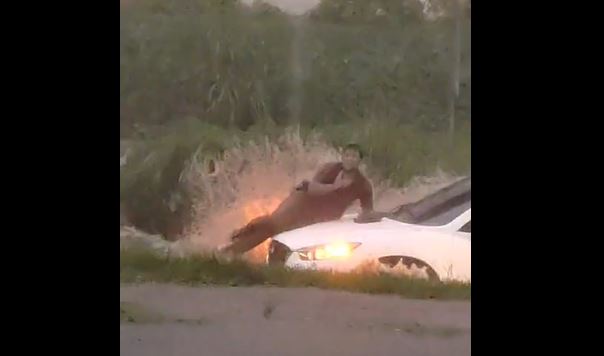 Un hombre que conducía una motocicleta en la ruta que une Mazatenango con San Francisco Zapotitlán fue arrastrado por la corriente que provocó el aguacero. Como pudo se puso a salvo en el capó de un carro varado en el ingreso a colonia Bilbao. (Foto Prensa Libre: Captura de pantalla).