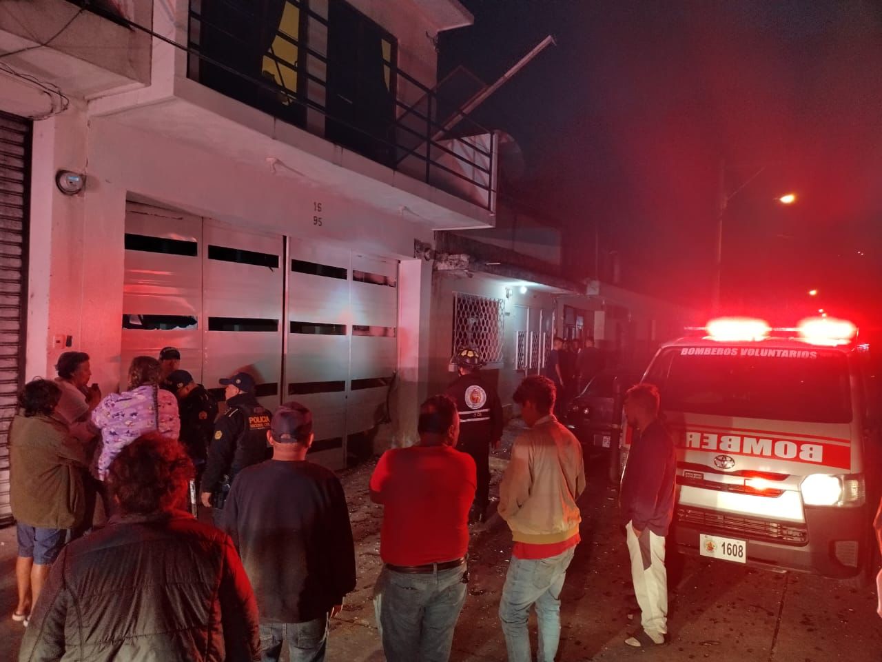 Vecinos observan frente a una vivienda ubicada en la 7 calle y 17 avenida de la zona 6 capitalina, en donde explotó un artefacto que dañó varias viviendas. (Foto Prensa Libre: Bomberos Voluntarios)