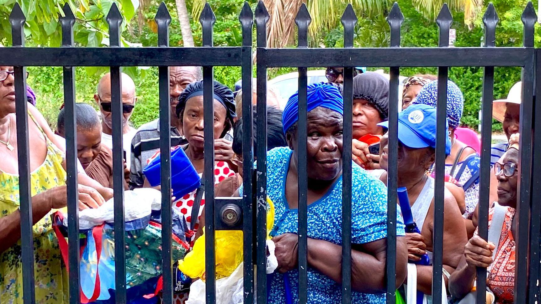Personas de bajos ingresos acuden a buscar comida a una iglesia de la Pequeña Haití.