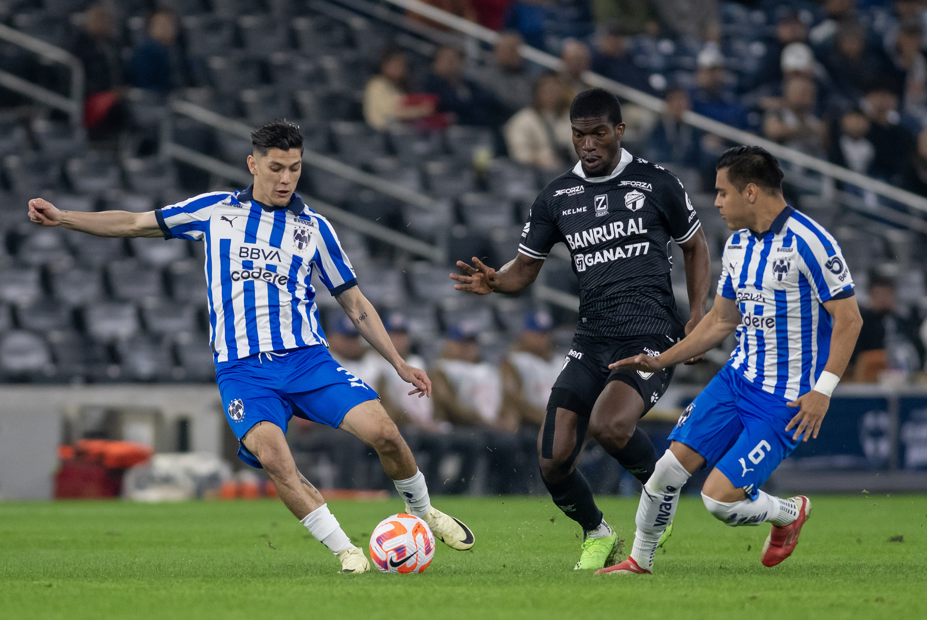 Gerardo Arteaga (i) y Edson Gutierrez (d) de Rayados disputan un balón con Azarias Londoño (c) de Comunicaciones este jueves, durante el partido entre Rayados de México y Comunicaciones. 
(Foto Prensa Libre: EFE).