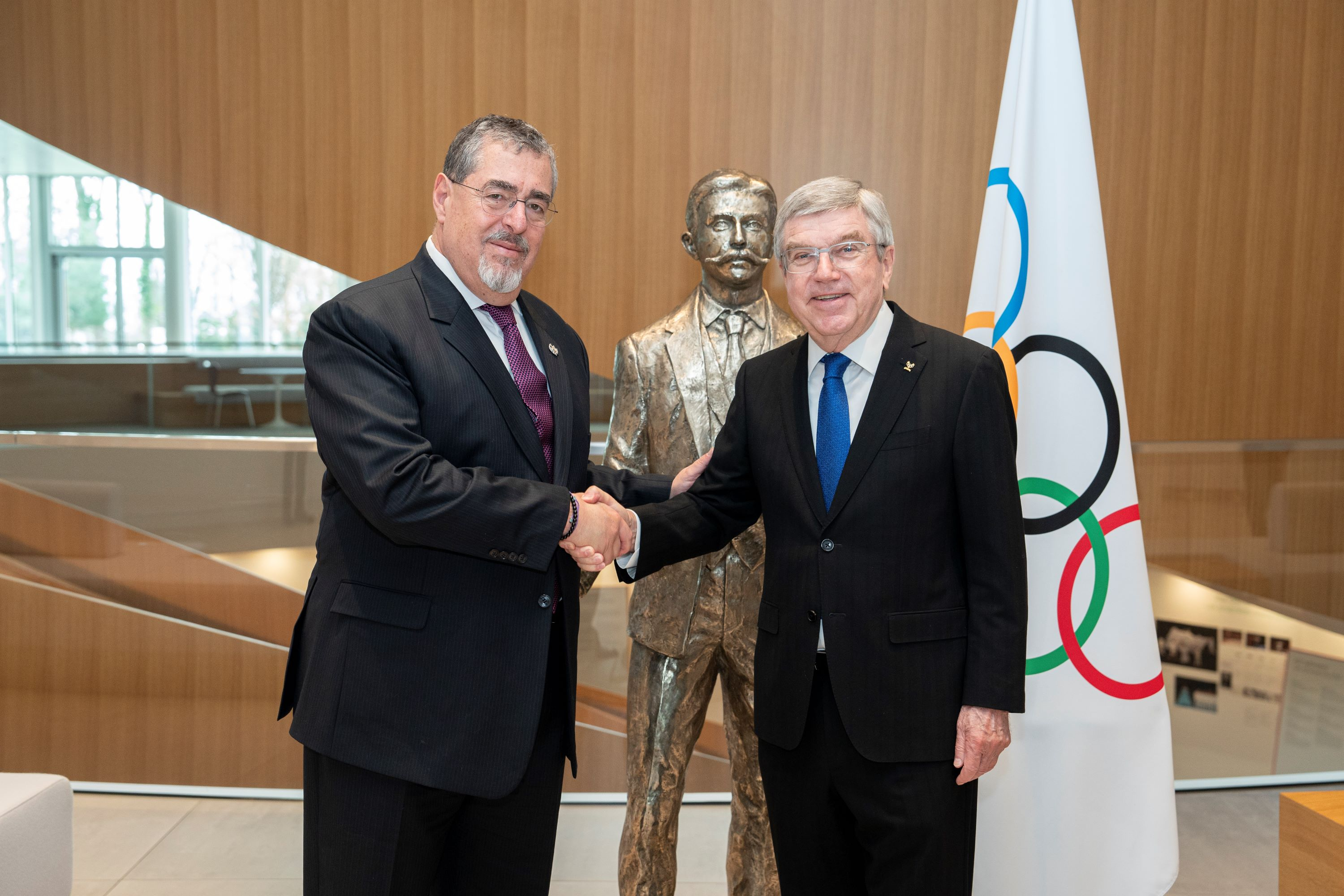 El presidente de Guatemala, Bernardo Arévalo de León (i), saluda al presidente del Comité Olímpico Internacional (COI), Thomas Bach, antes de una reunión durante su visita al COI. (Foto Prensa Libre: EFE).