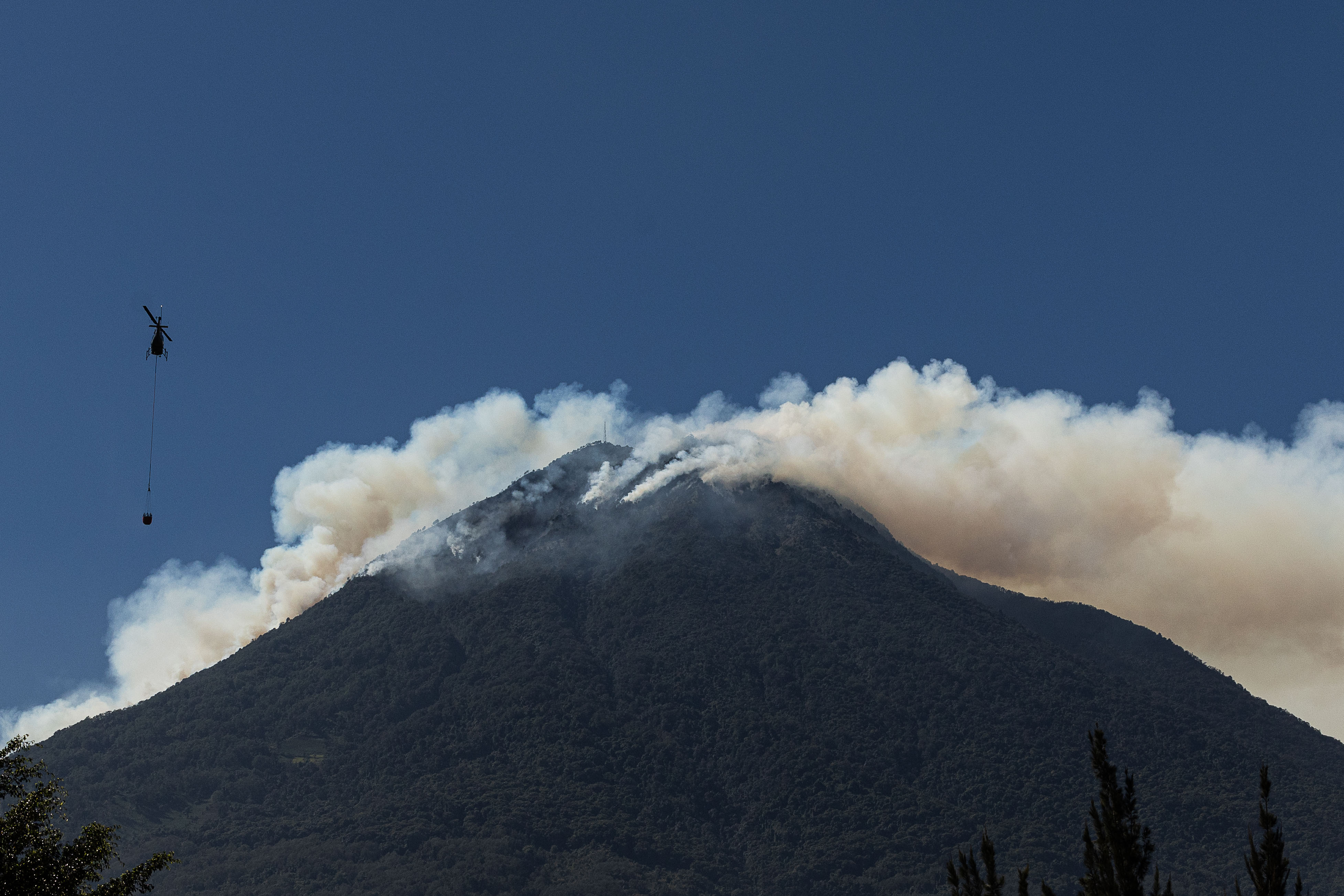 Un helicóptero trabaja en el control de un incendio forestal en el Volcán de Agua este jueves cerca de Antigua Guatemala. (Foto Prensa Libre: EFE)