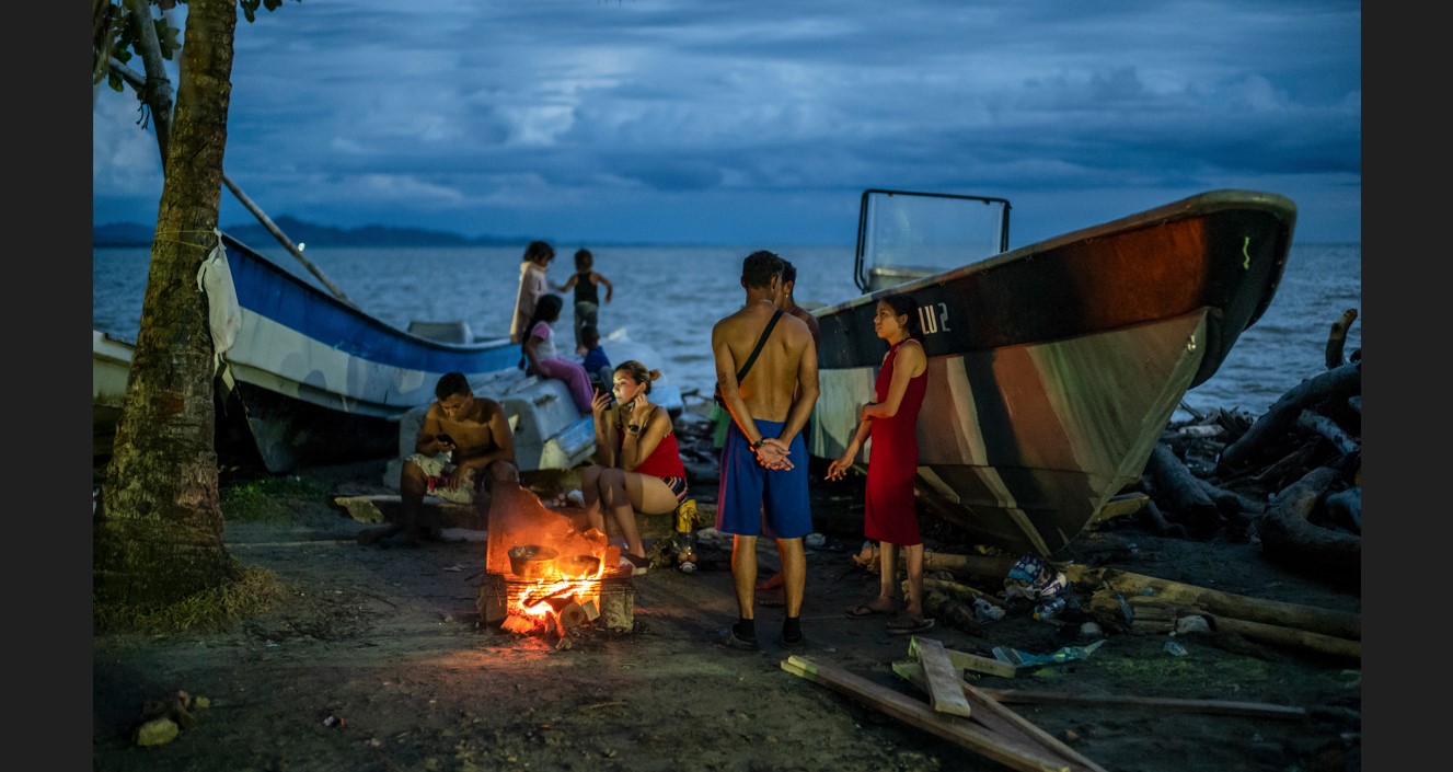 Personas de Venezuela y Cuba a la espera en Necoclí, Colombia, antes de cruzar el Darién con la esperanza de llegar a EE. UU. (Federico Rios/The New York Times)