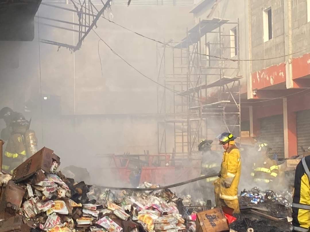 Socorristas combaten incendio en locales comerciales de la zona 3 de Xela. (Foto Prensa Libre: Quinta Compañía de CVB)