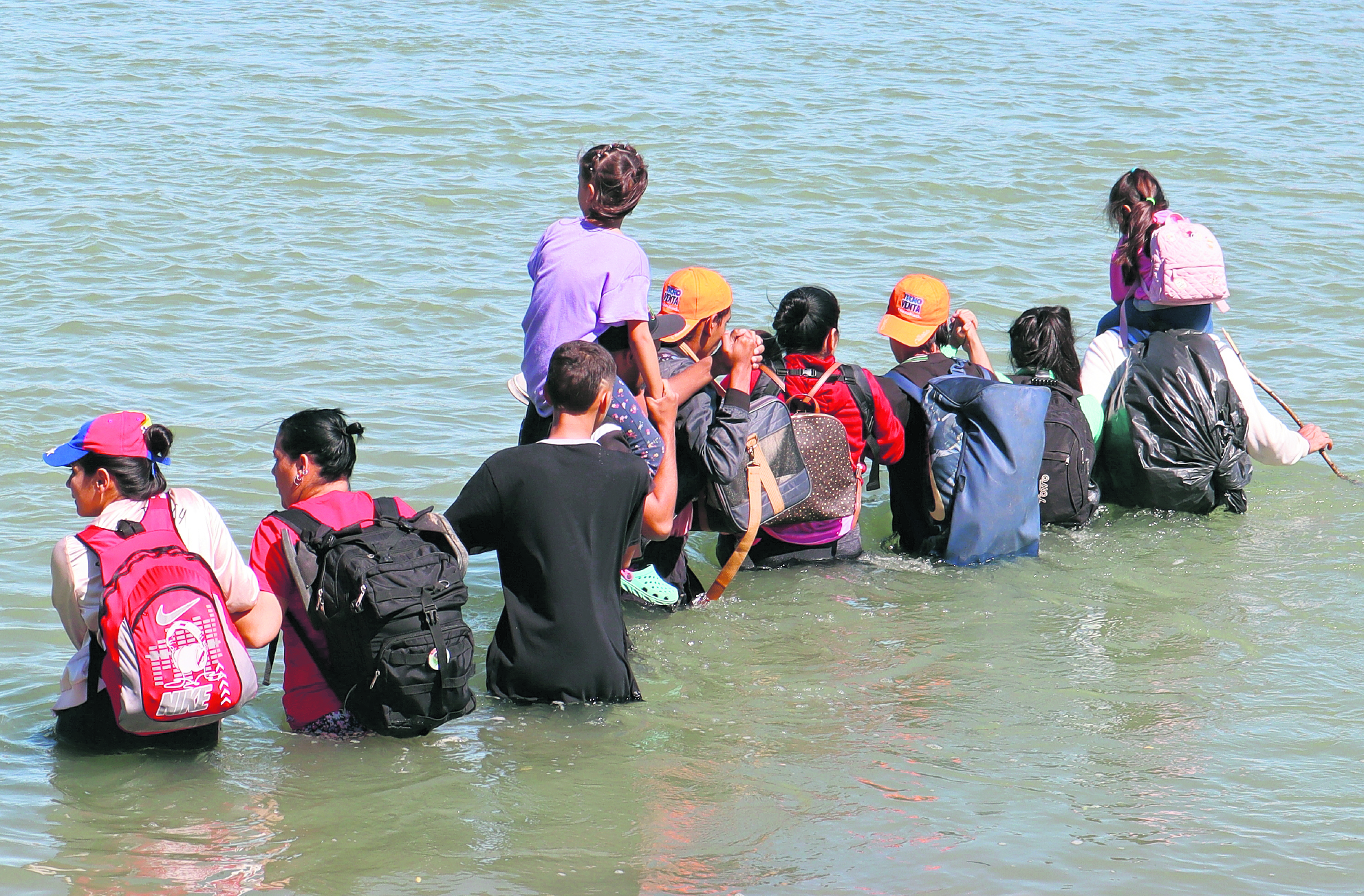 AME137. PIEDRAS NEGRAS (MÉXICO), 23/10/2023.- Migrantes intentan cruzar la frontera con Estados Unidos nadando, el 18 de octubre de 2023 en Piedras Negras (México). Paola (nombre ficticio para proteger su identidad) escanea el río con la mirada. Sus compañeros -un grupo de seis adultos, cinco niños y un bebé en brazos- ya están dentro. El agua les llega hasta la cintura. "Estoy nerviosa, pero yo vine a esto", dice a EFE la joven, antes de cruzar la última frontera en la travesía desde su natal Venezuela a Estados Unidos. EFE/ Octavio Guzmán