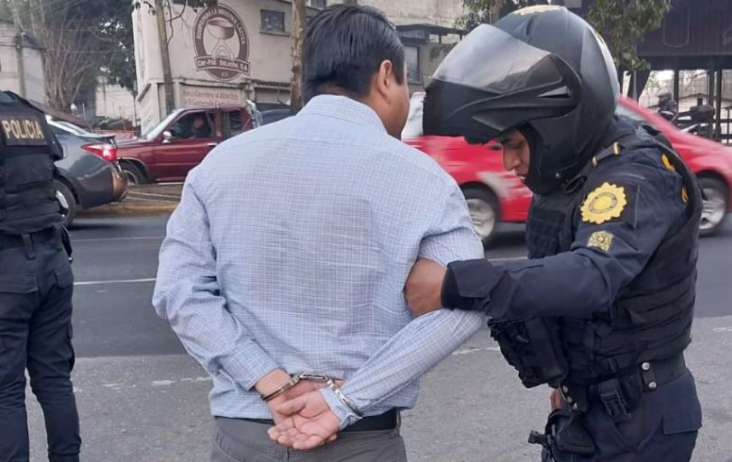 Agente de la PNC detiene al piloto que atropelló a un  PMT en la ruta al Atlántico, zona 17 de la ciudad de Guatemala. (Foto Prensa Libre: PMT)